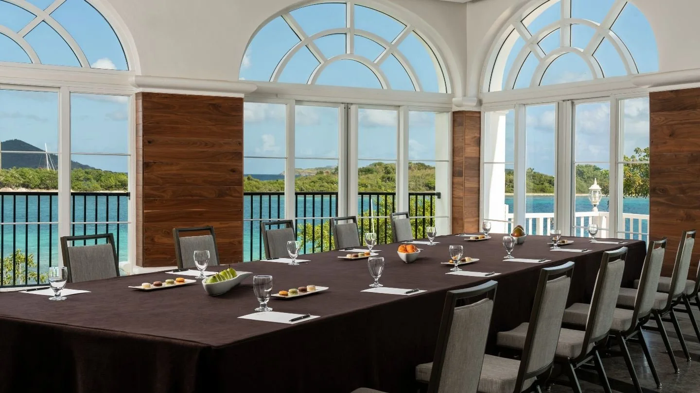 Elegant hotel conference room with a large meeting table and a scenic panoramic river view.
