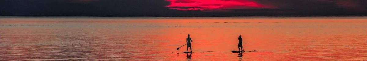 Paddleboarding on Lake Huron as the sun sets over Goderich, Ontario. Streaming Inc. helps capture the beauty and excitement of events in Goderich, from conferences to outdoor adventures, with professional video production and live streaming.