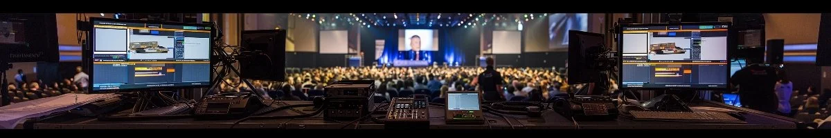 An ultra-wide 6:1 signature image of the Streaming Inc. technical production riser during a high-stakes corporate conference, showcasing our professional redundant encoders, multi-camera setups, and broadcast-quality hybrid event production.