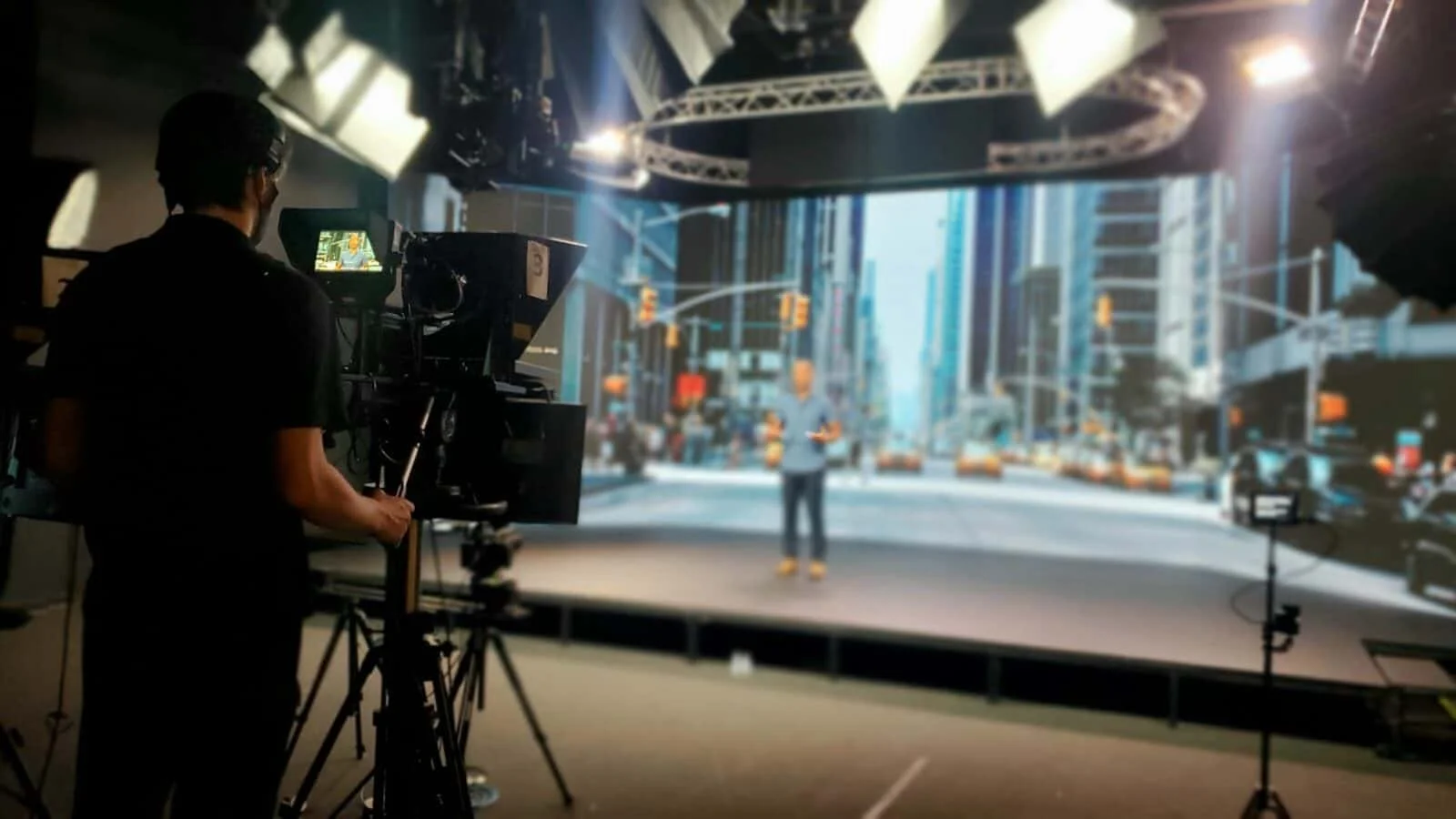 A wide panoramic view of a professional hybrid event broadcast setup by Streaming Inc., featuring multi-camera production, high-end stage lighting, and a digital cityscape backdrop for a corporate conference in the GTA-West corridor.