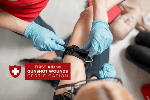 Person receiving first aid training for gunshot wound, with a certificate and gloves visible.