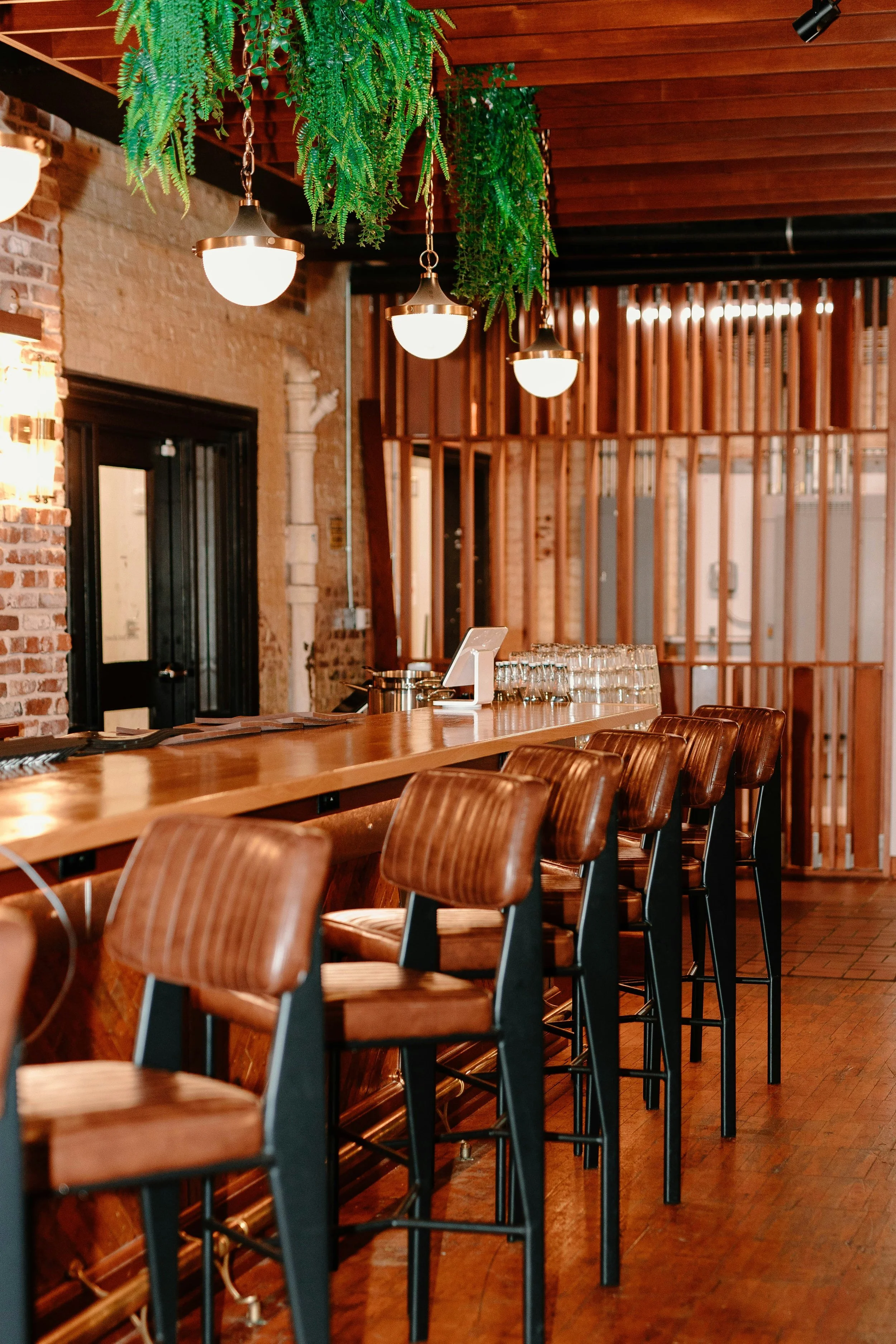 Warmly lit restaurant dining room with wooden tables and ambient lighting, showcasing an inviting hospitality atmosphere