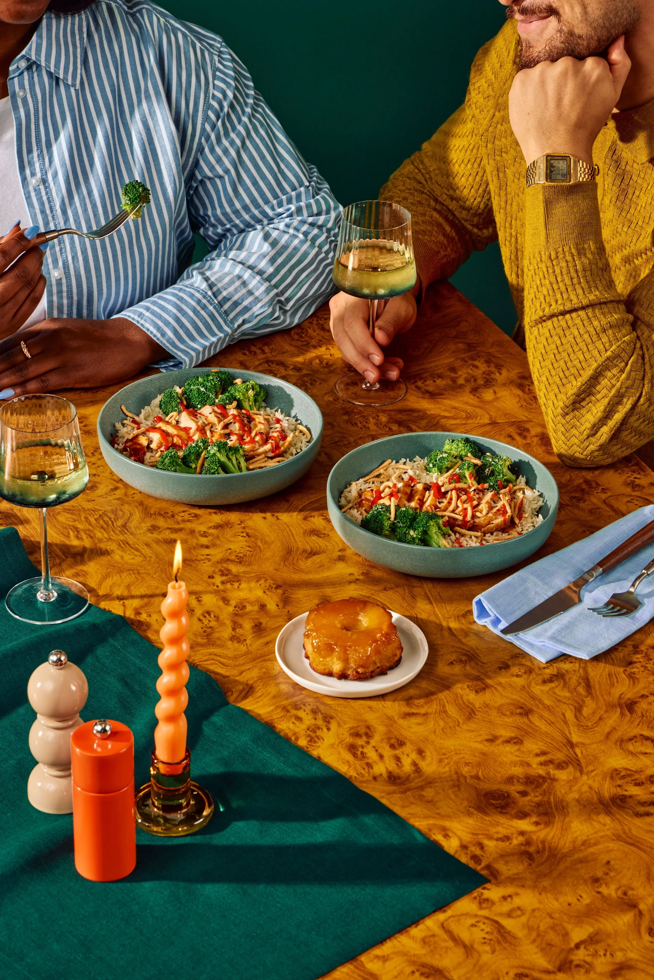 Overhead view of two colorful grain bowls with fresh toppings styled on a warm neutral surface for a restaurant client