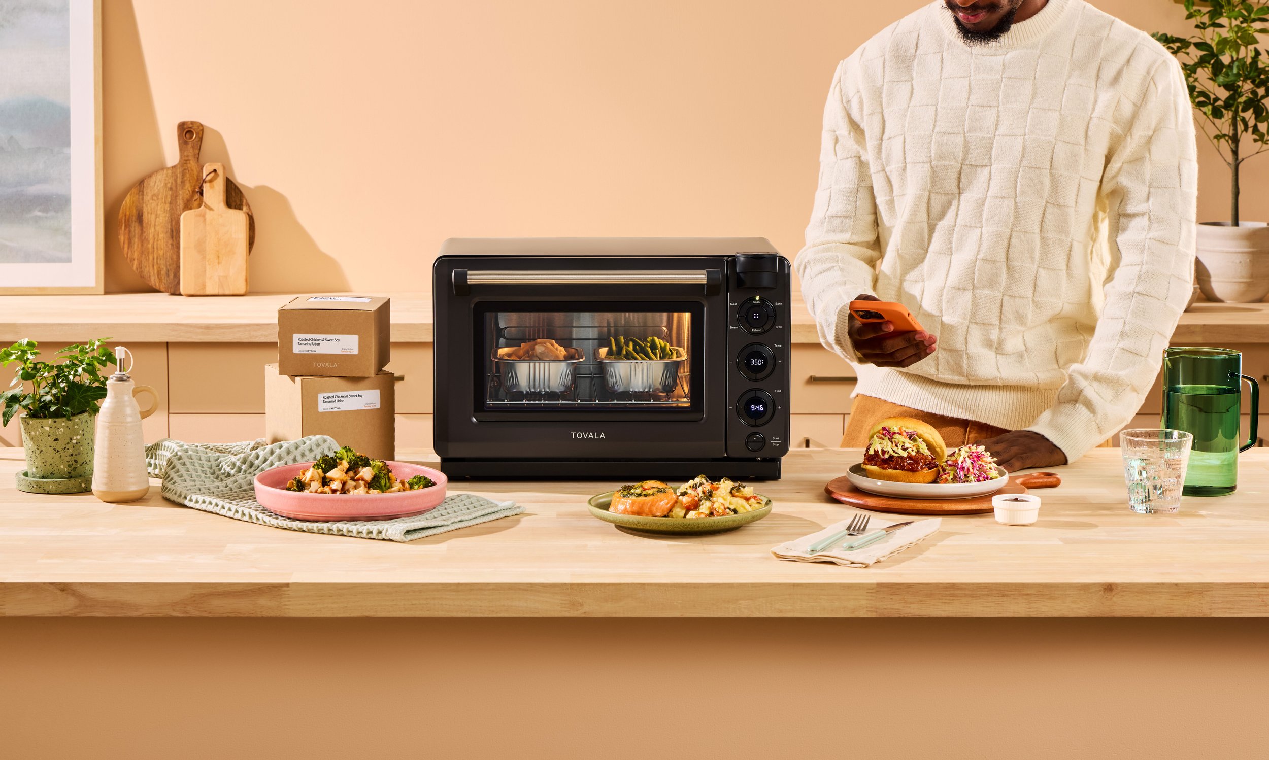 Tovola countertop oven displayed on a kitchen counter beside freshly baked food, styled for approachable product photography