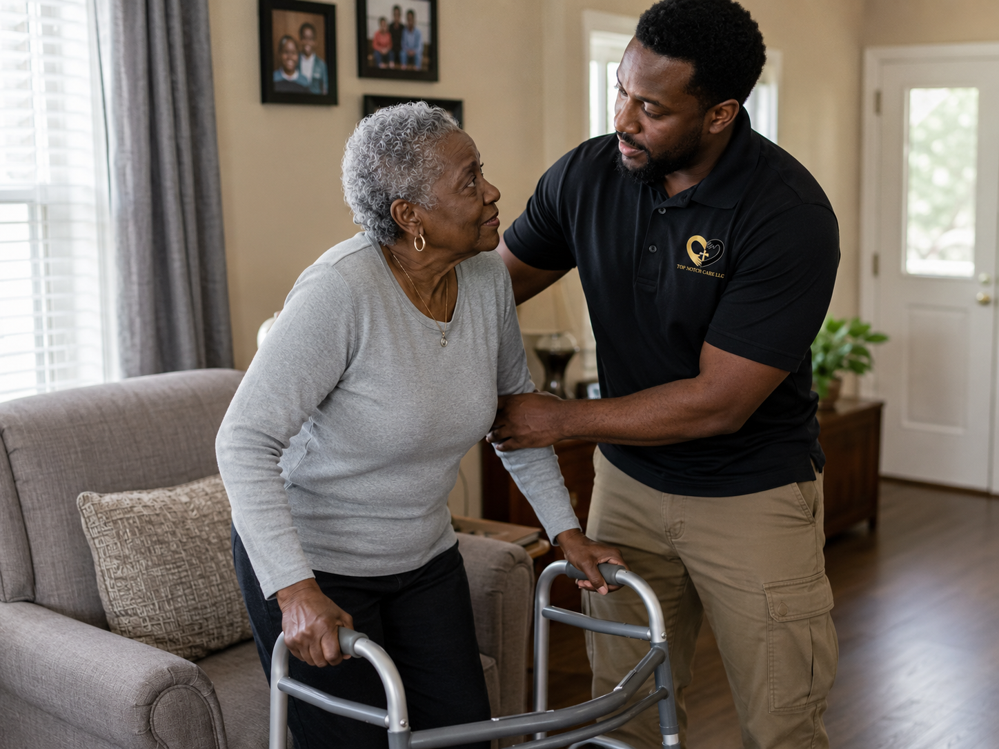 Caregiver helping an older woman stand safely and use her walker at home.