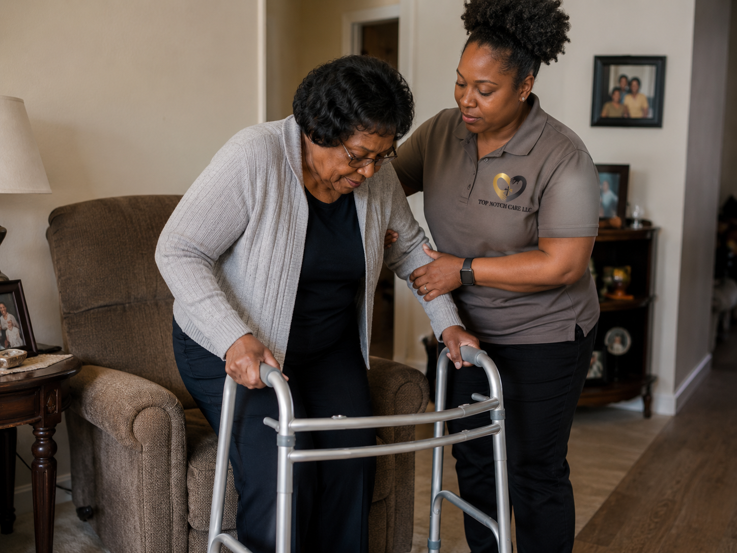Top Notch Care personal care attendant safely supports an older woman using a walker in her home.