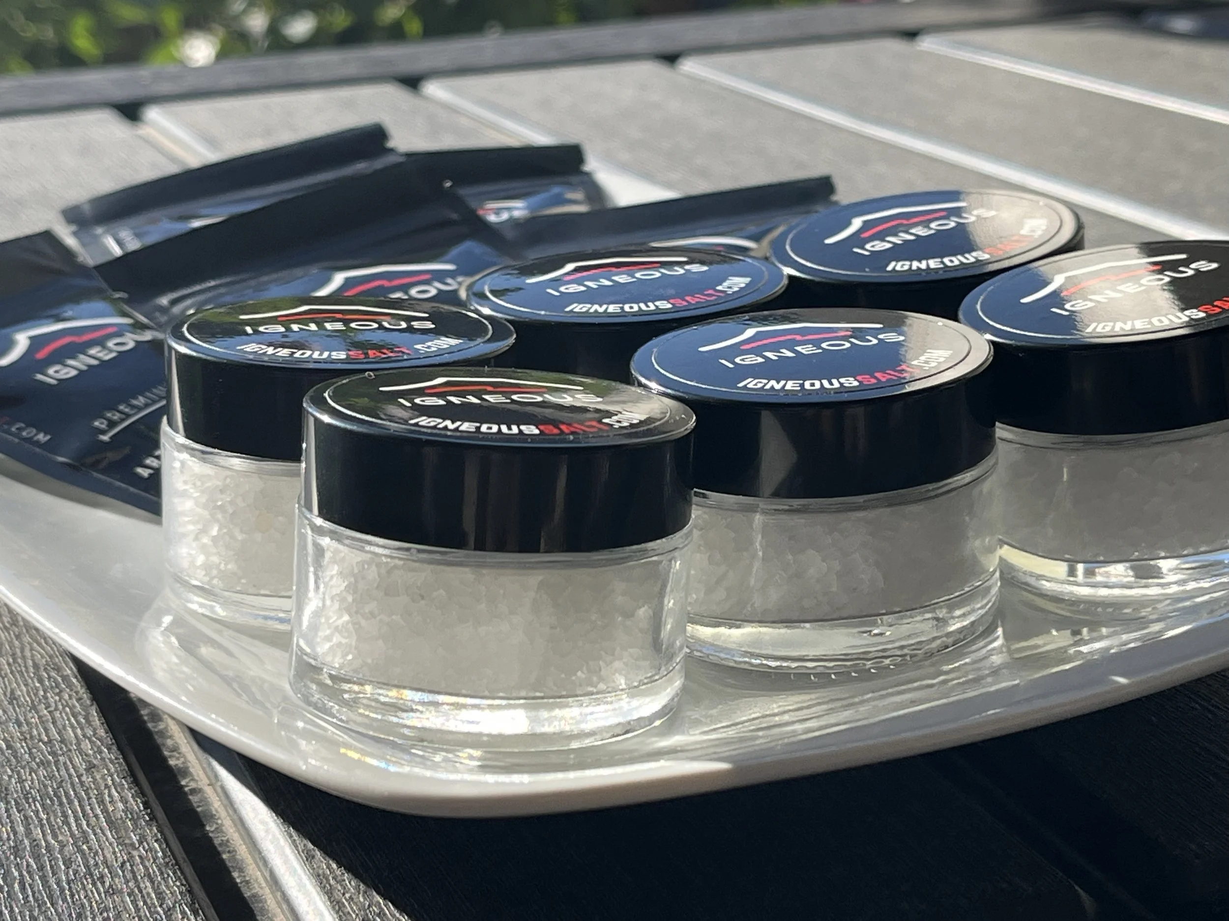 Small containers of salt and a pack of pepper on a tray.