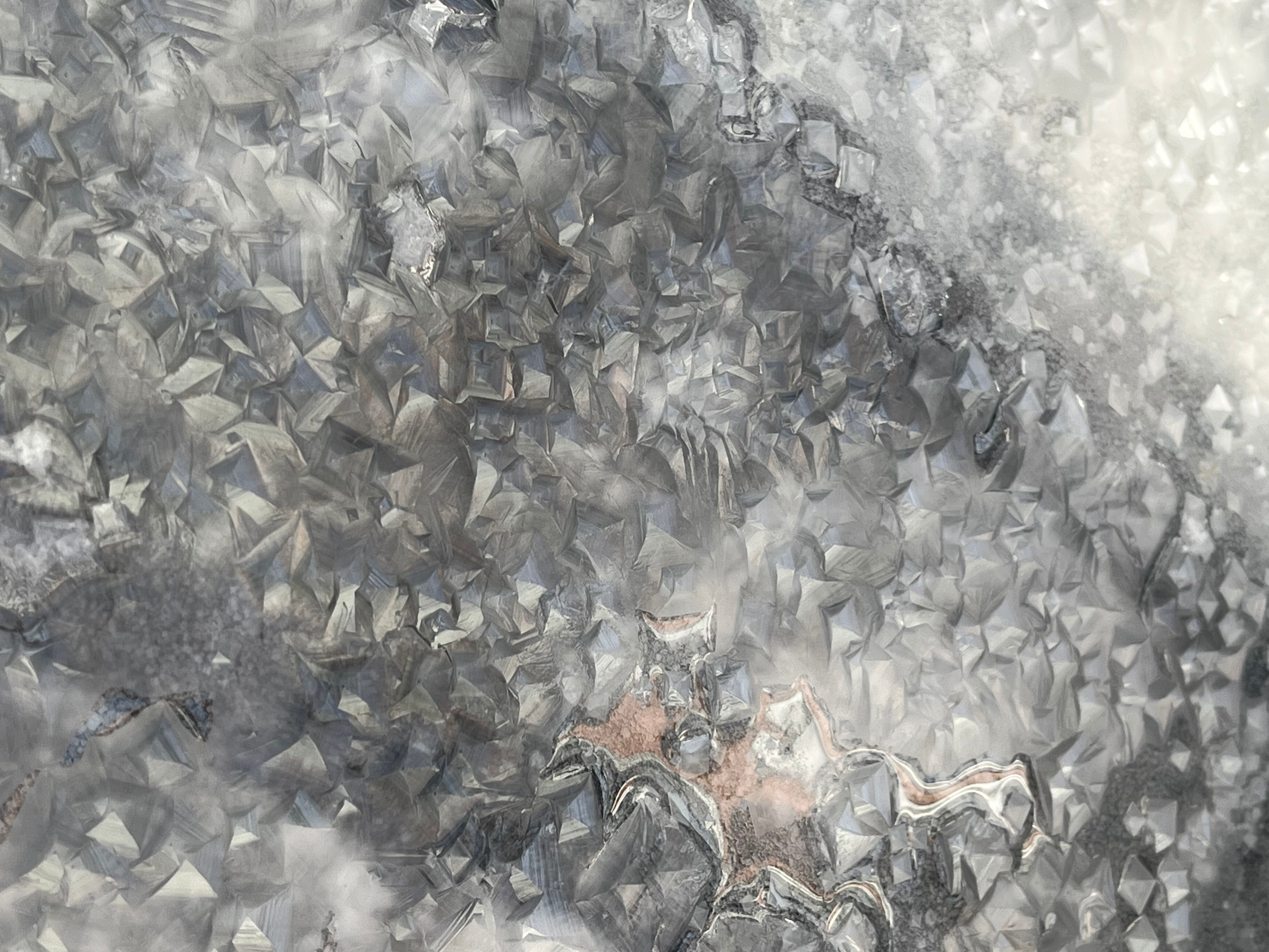 Close-up of a metallic, crystalline surface with reflective, angular facets.