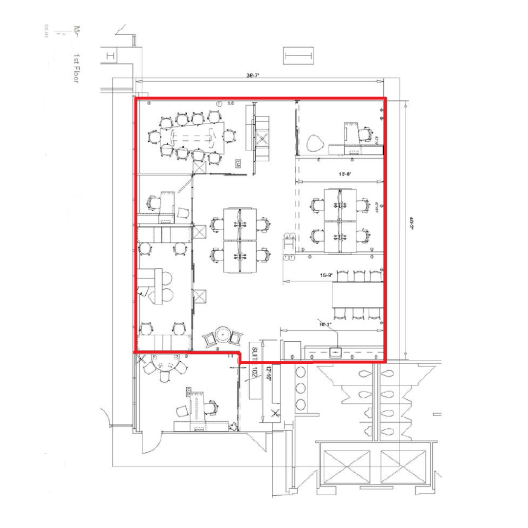 Architectural floor plan of an office space with multiple rooms, conference areas, and workstations, outlined in red.