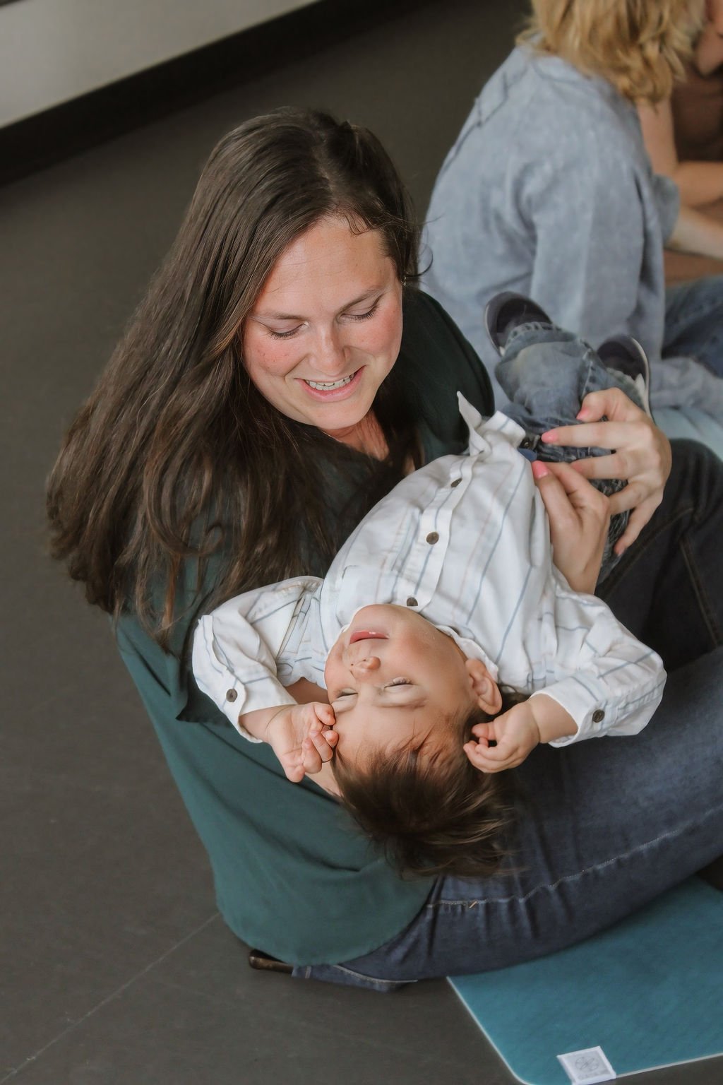 mom snuggling and playing with her toddler in music class