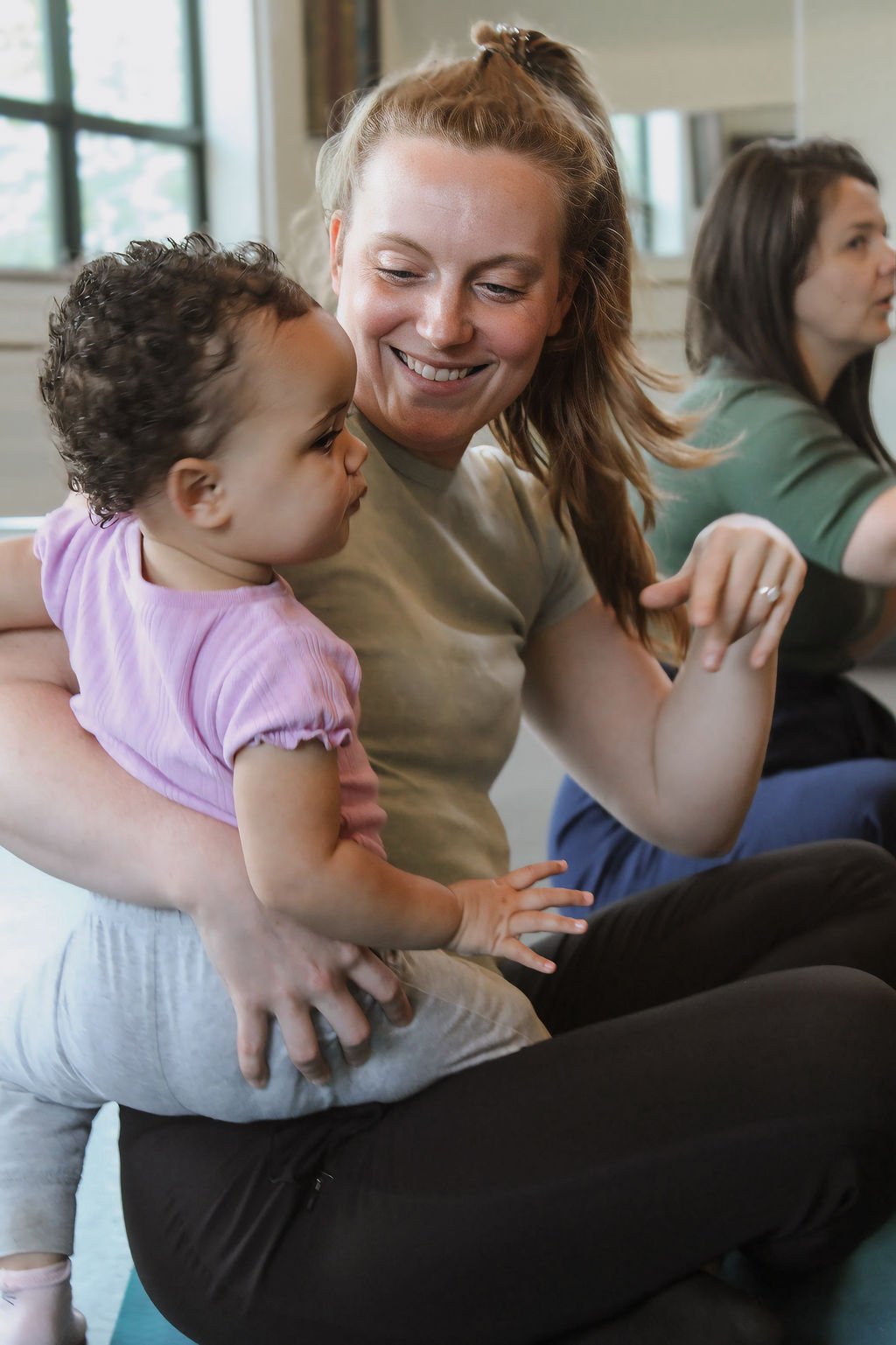 Mom smiling with toddler in Music Together class