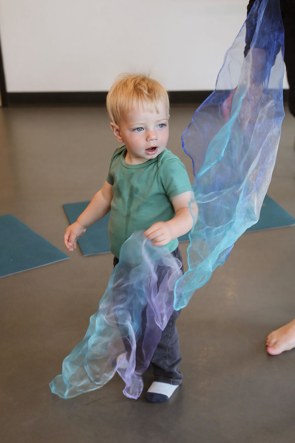 toddler with scarf in music class