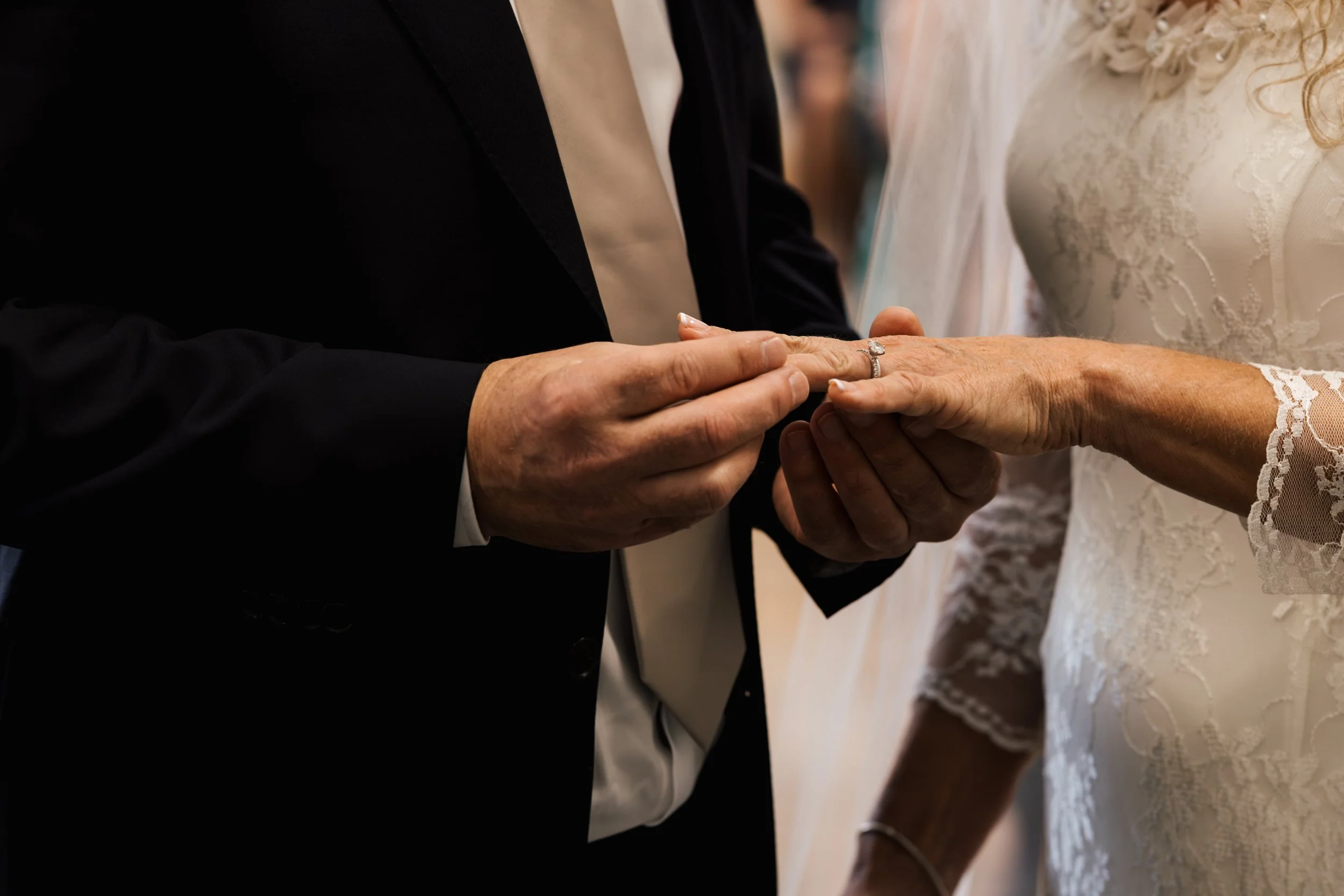 A couple exchanging wedding rings during their wedding ceremony.