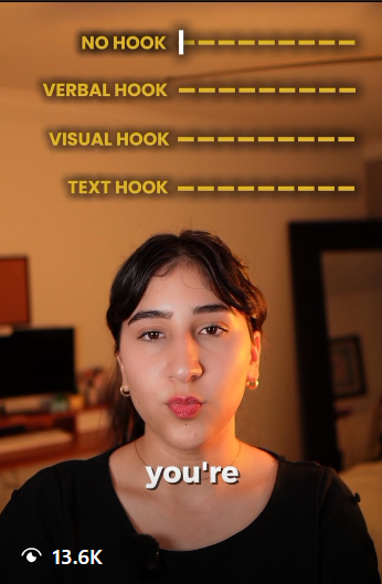 A woman is speaking into a camera with a list of different types of hooks displayed on the wall behind her, including 'No Hook', 'Verbal Hook', 'Visual Hook', and 'Text Hook', each with dotted lines indicating space for content. The word 'you're' is overlaid at the bottom of the image.
