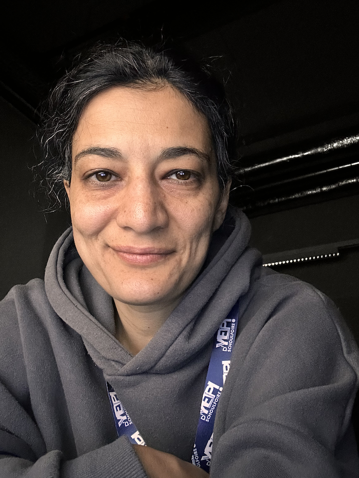 Profile picture of Sahar Niknam in a dark lab, smiling at the camera.