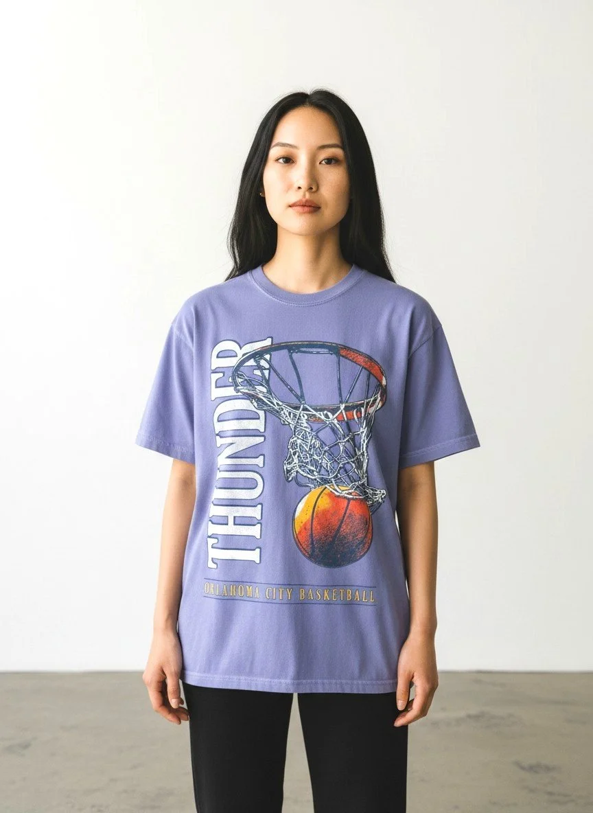 Model wearing Shop Good's periwinkle OKC Thunder "Posterizer" tee with a basketball hoop graphic