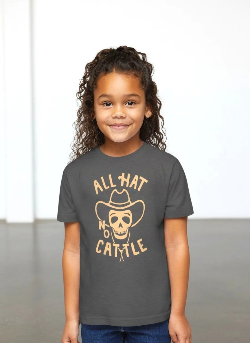 Child wearing Shop Good's charcoal "All Hat No Cattle" western tee with a cowboy-hat skull graphic