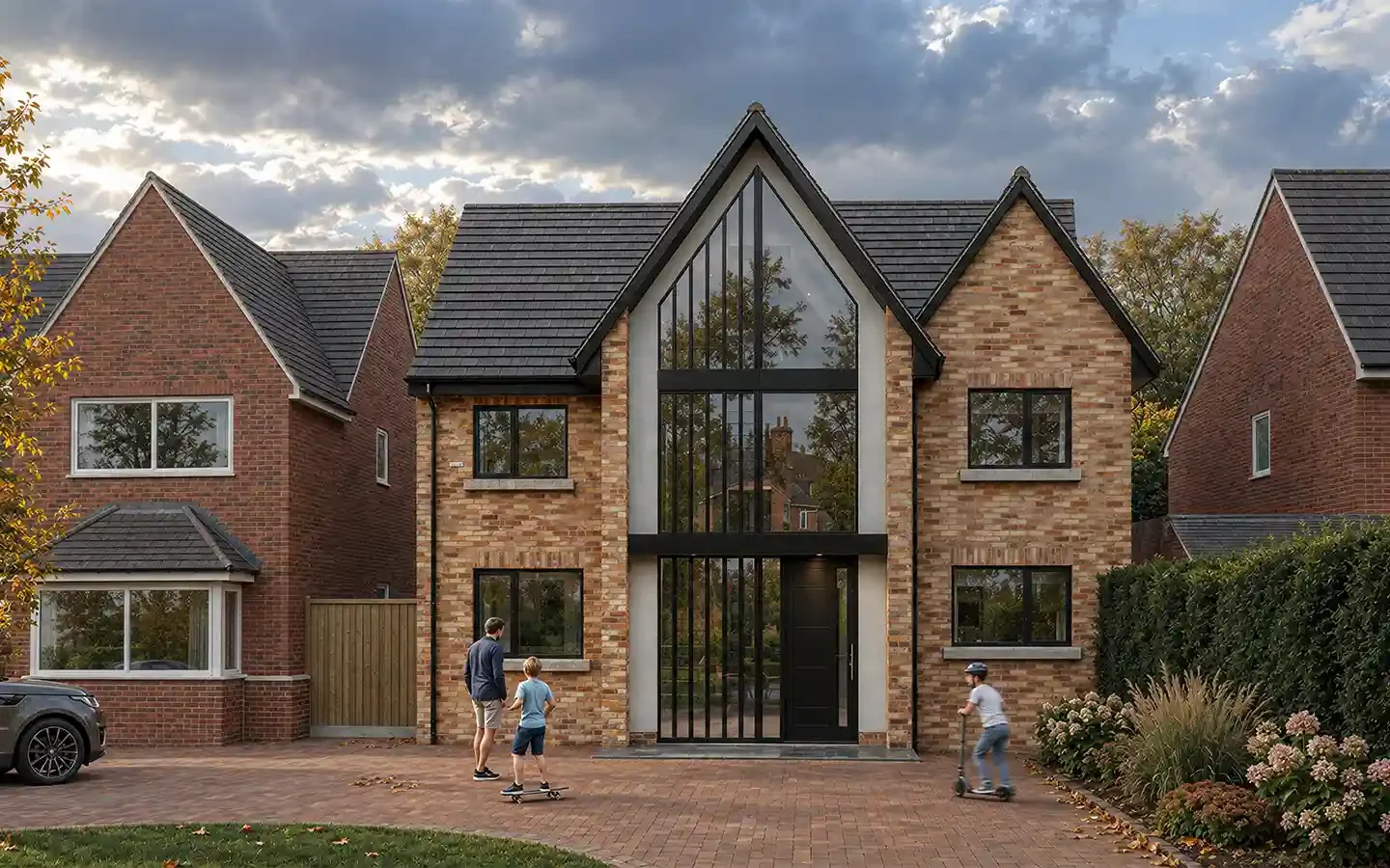 Front view of a remodelled house in Dorridge, showing a contemporary three-storey extension with full-height gable glazing, brick-slip cladding and replacement windows.