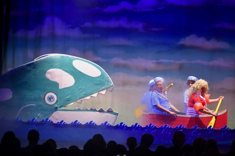 A whale chases a boat in a performance of Pinocchio panto script