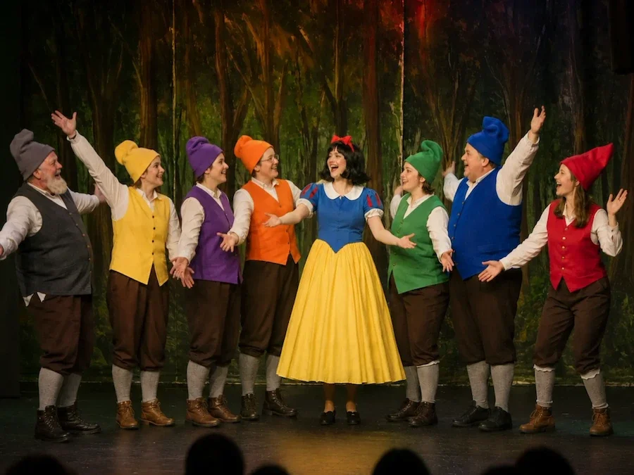 Snow White meets the Seven Dwarves in the forest.