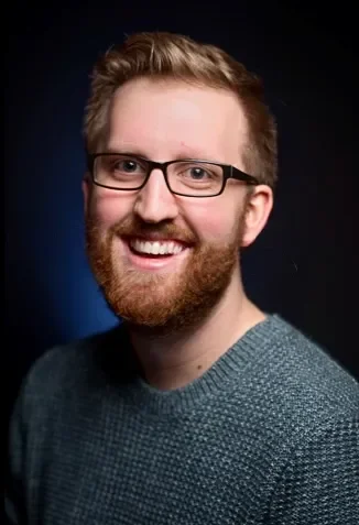 Nick Lawrence, pantomime musical director, smiling in headshot photo