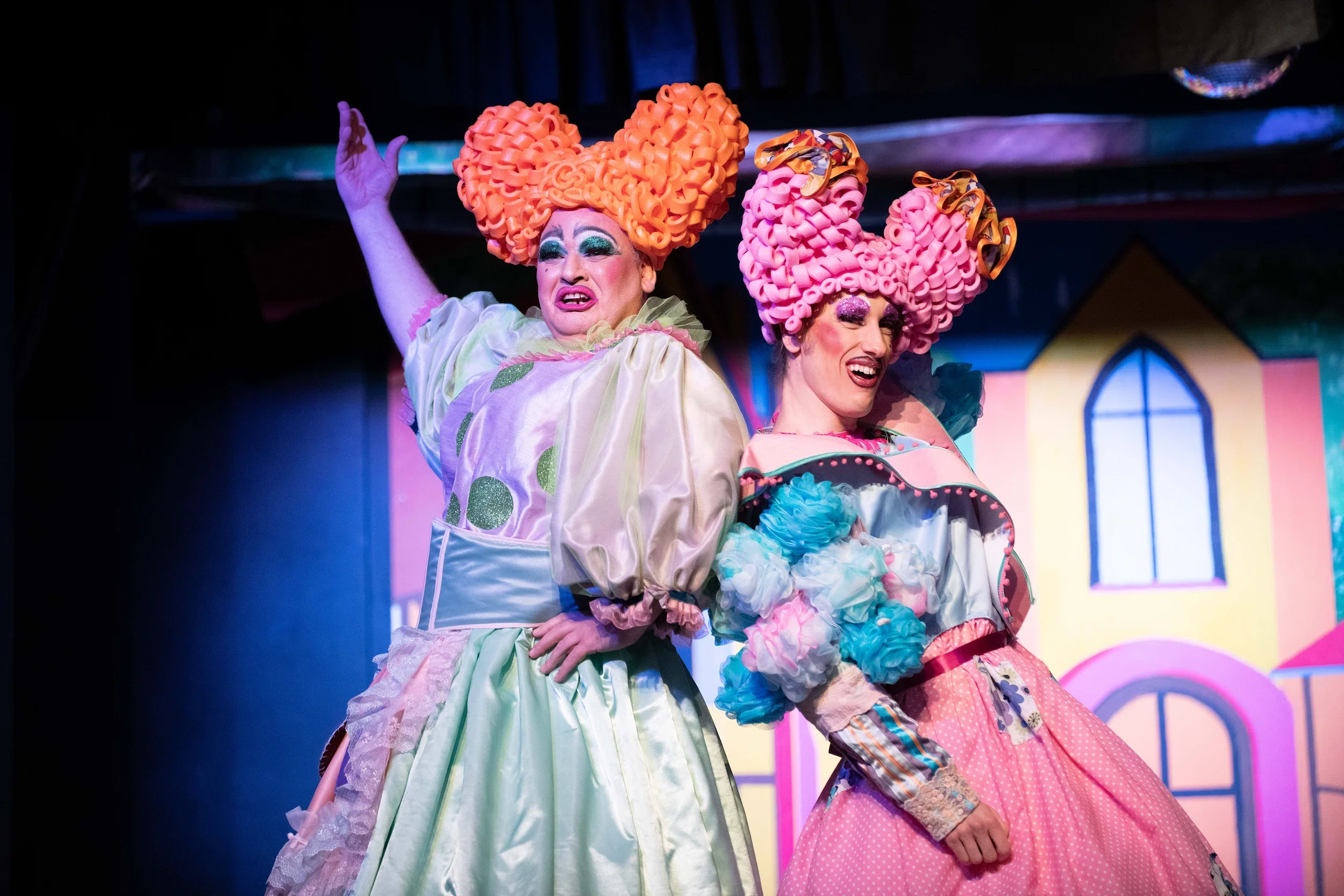 Two brightly dressed pantomime dames in a production of Cinderella