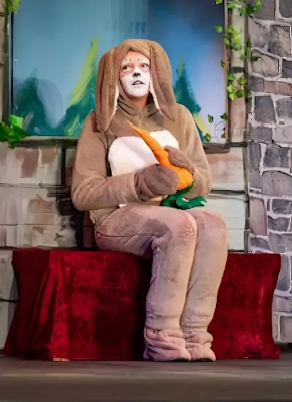 Rascal, the human-sized, talking rabbit, eating a large orange carrot