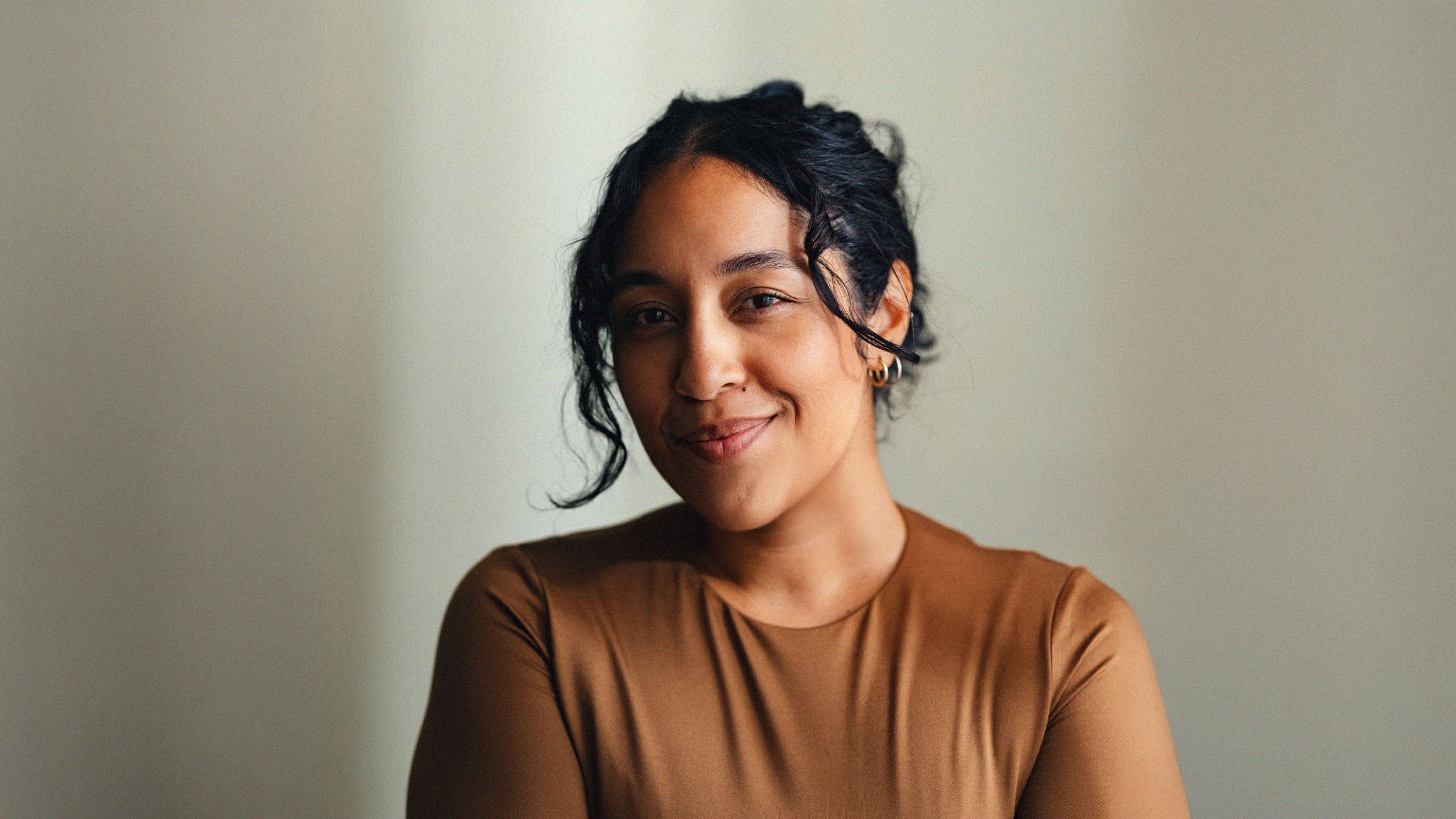 A happy mixed woman breaking the fourth wall smiling