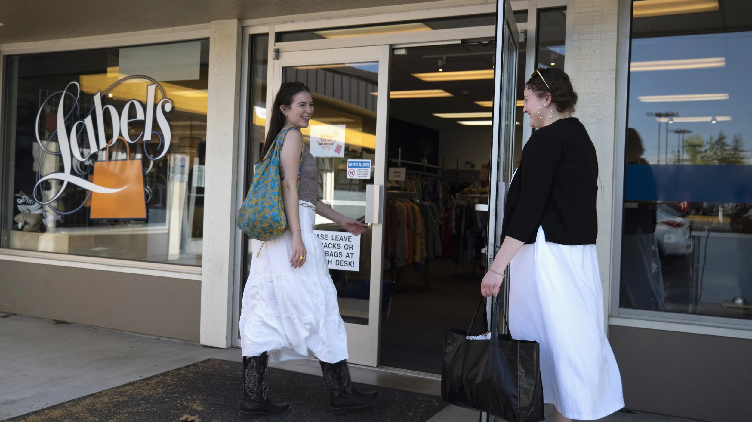 Two girls walking into the front doors of the James Street location.