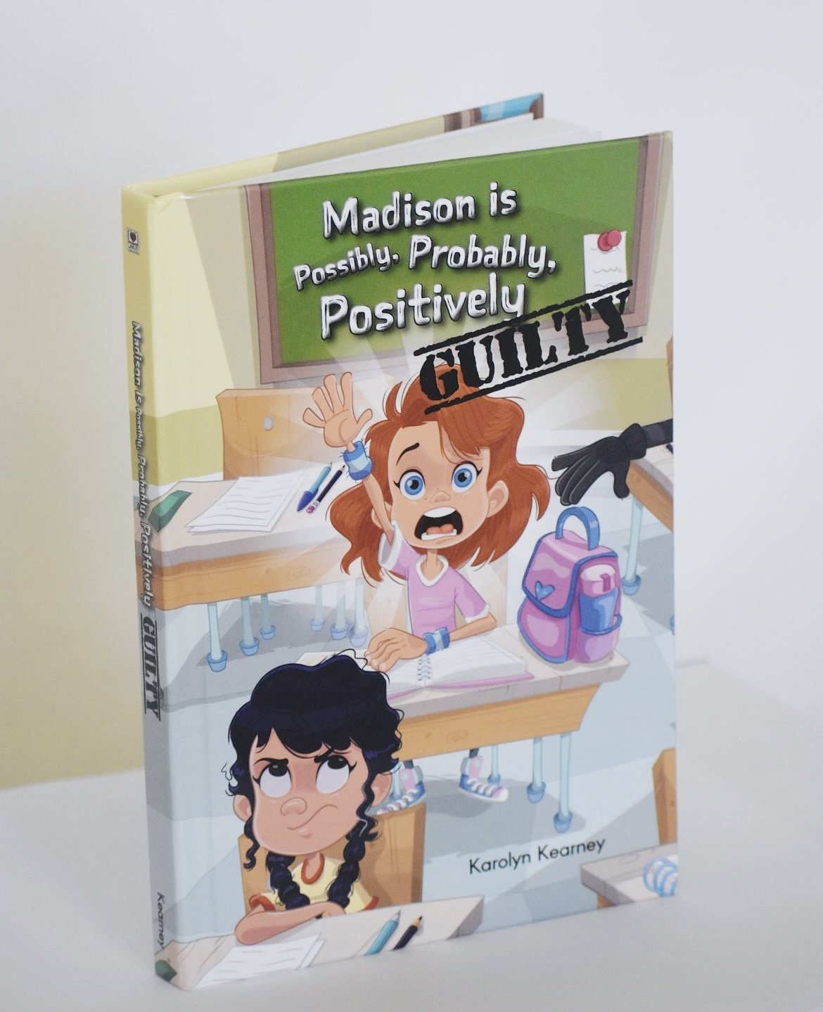 Book cover of Madison Is Possibly, Probably, Positively Guilty by Karolyn Kearney, featuring two middle school girls in a classroom and a bold “Guilty” stamp across the title.