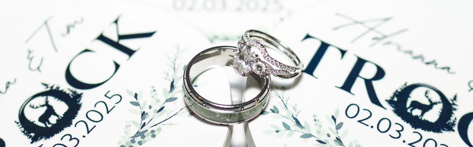Close-up of wedding rings and engagement ring placed on a wedding invitation