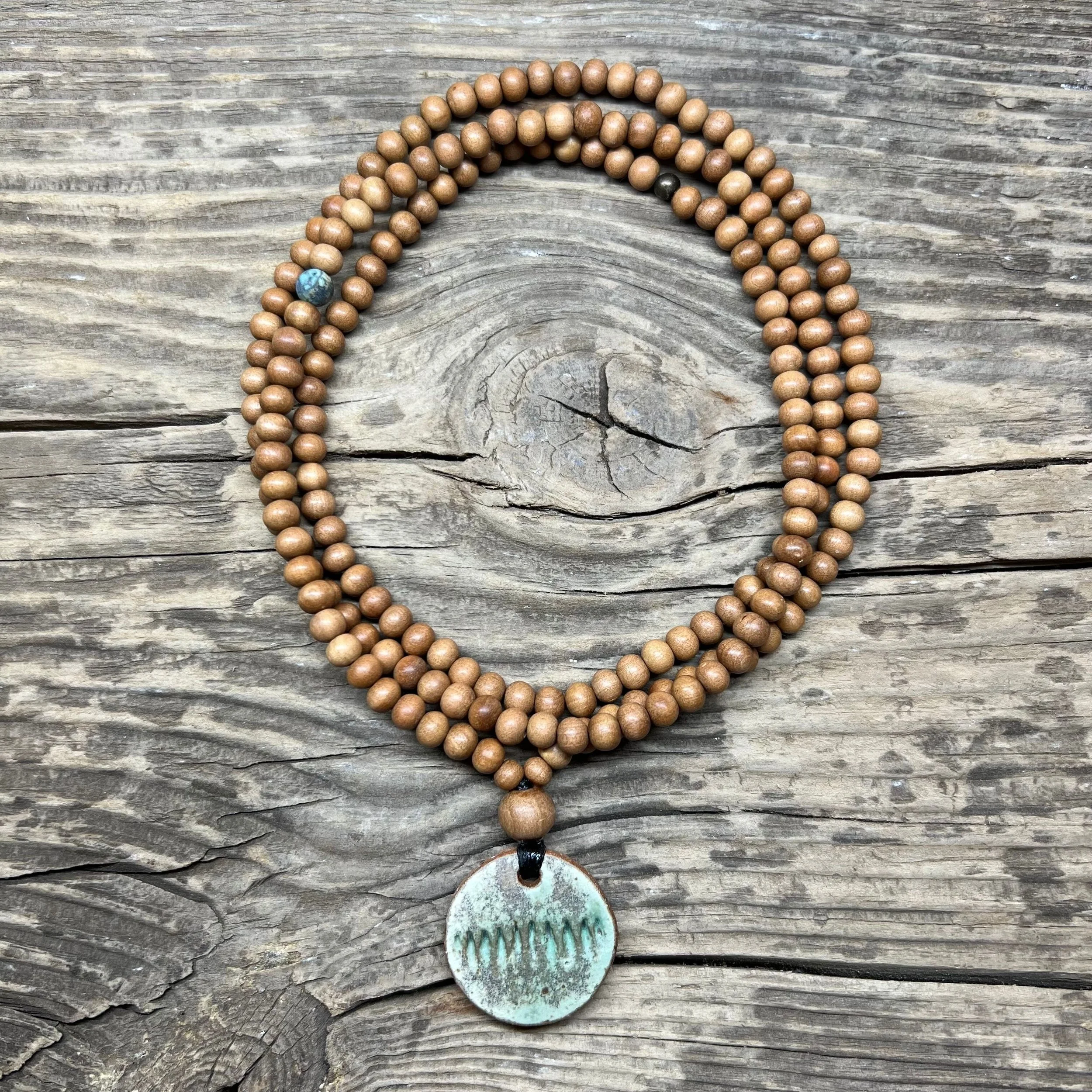 Round ceramic pendant with green glaze and sandalwood bead necklace