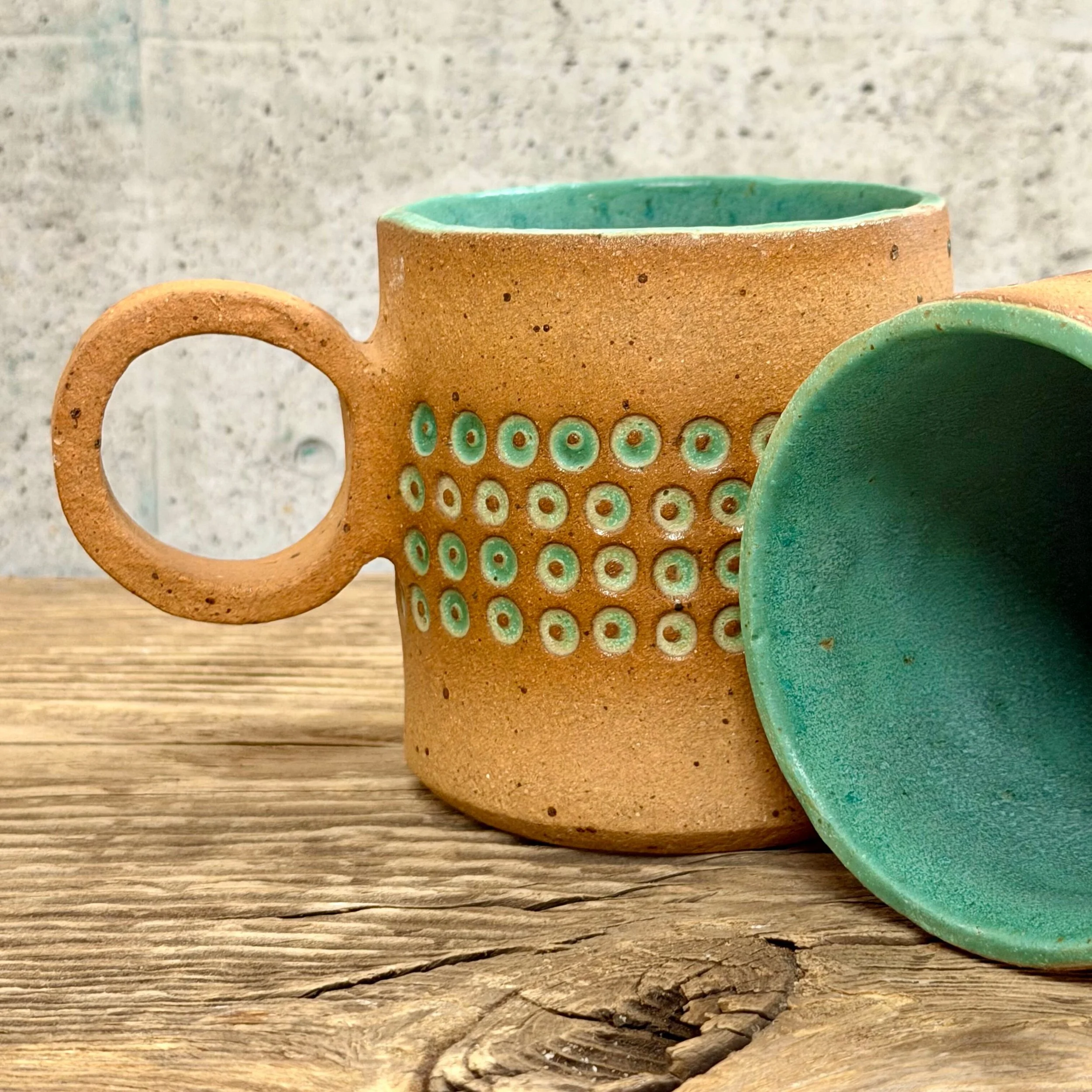 handcrafted cup, made from speckled stoneware clay.   Finished in a beautiful satin patina green glaze on the inside, inlaid on the outside with a comfortable circular handle.