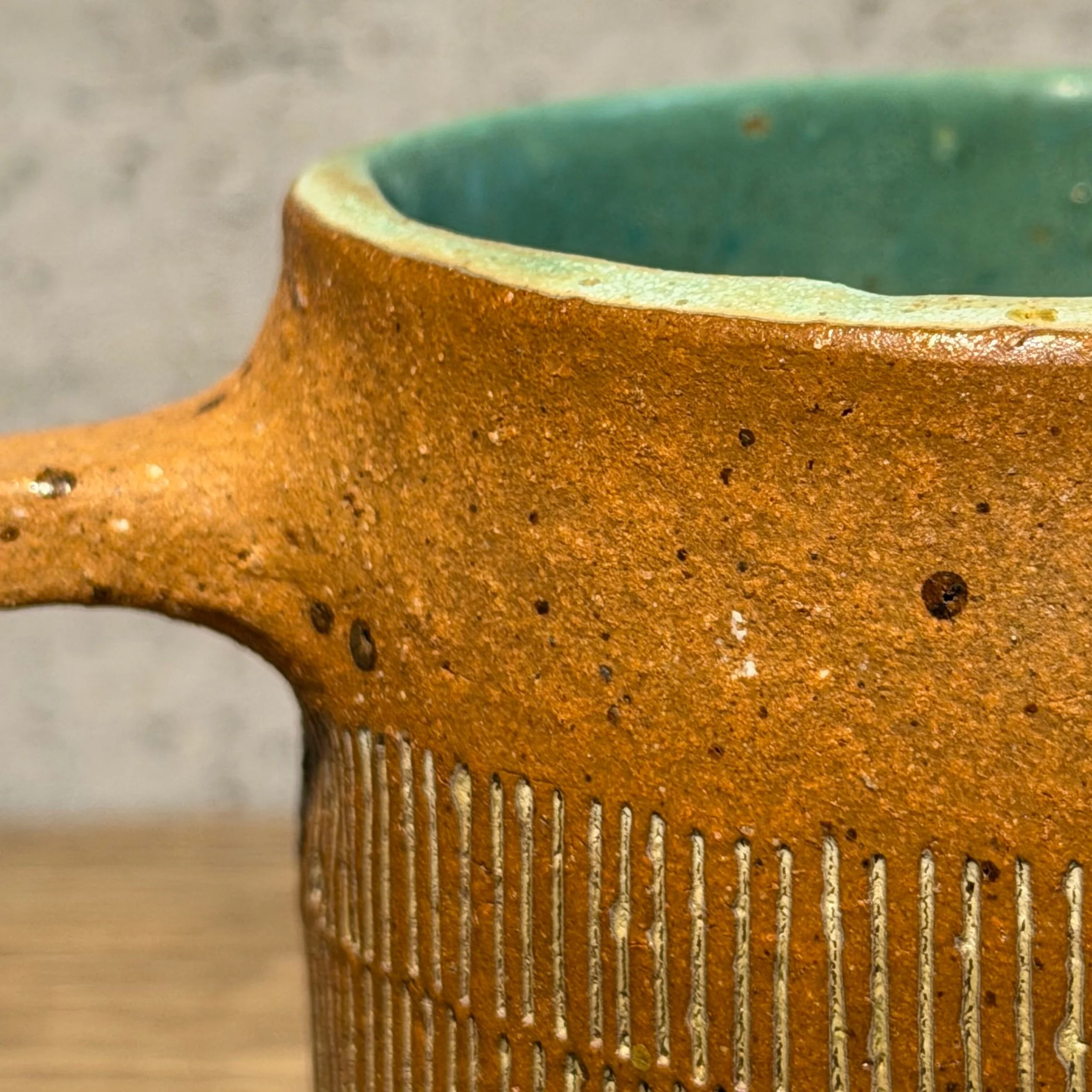 handcrafted cup, made from speckled stoneware clay.   Finished in a beautiful satin patina green glaze on the inside, inlaid on the outside