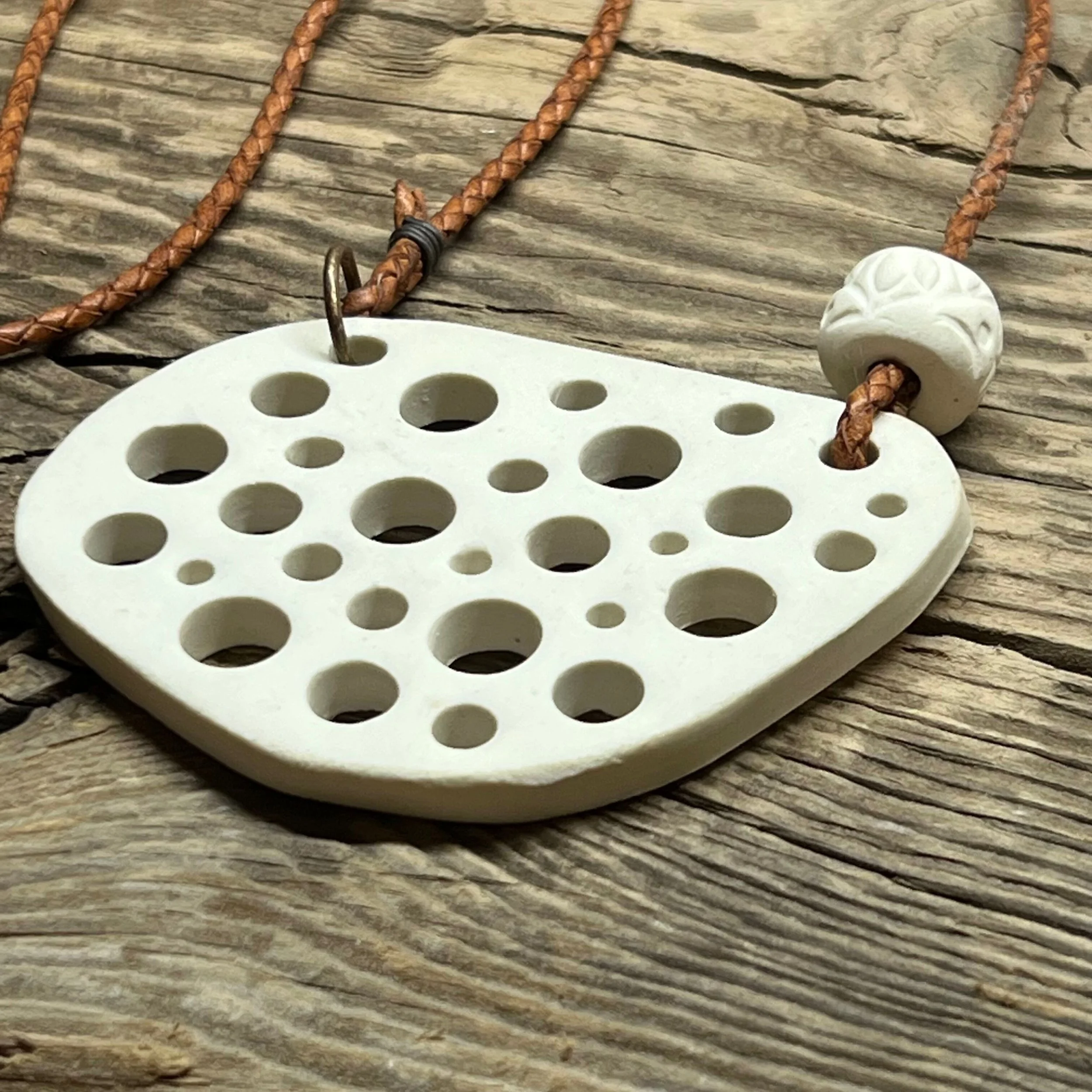 smooth white stoneware clay pendant and a handmade bead