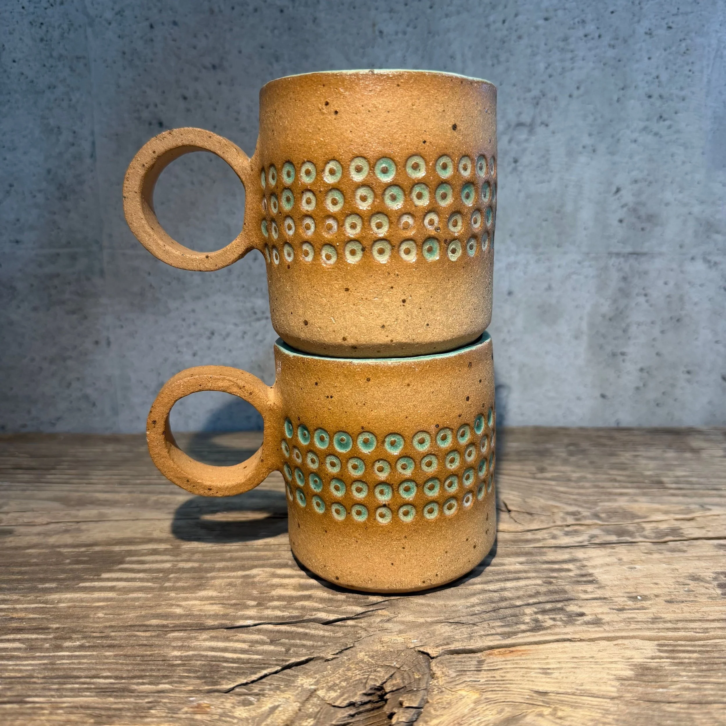 handcrafted cup, made from speckled stoneware clay.   Finished in a beautiful satin patina green glaze on the inside, inlaid on the outside with a comfortable circular .handle.