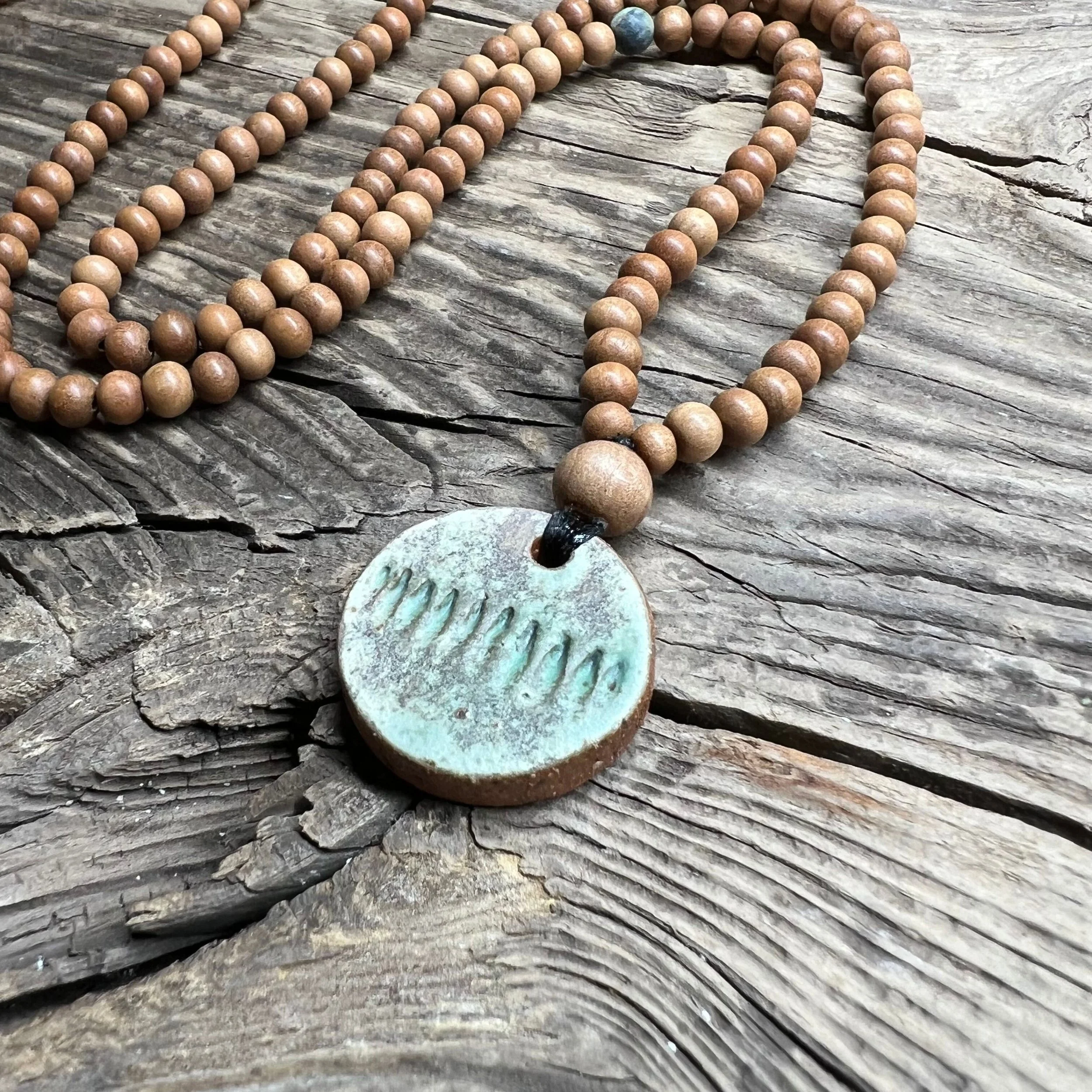 Round ceramic pendant with green glaze and sandalwood bead necklace