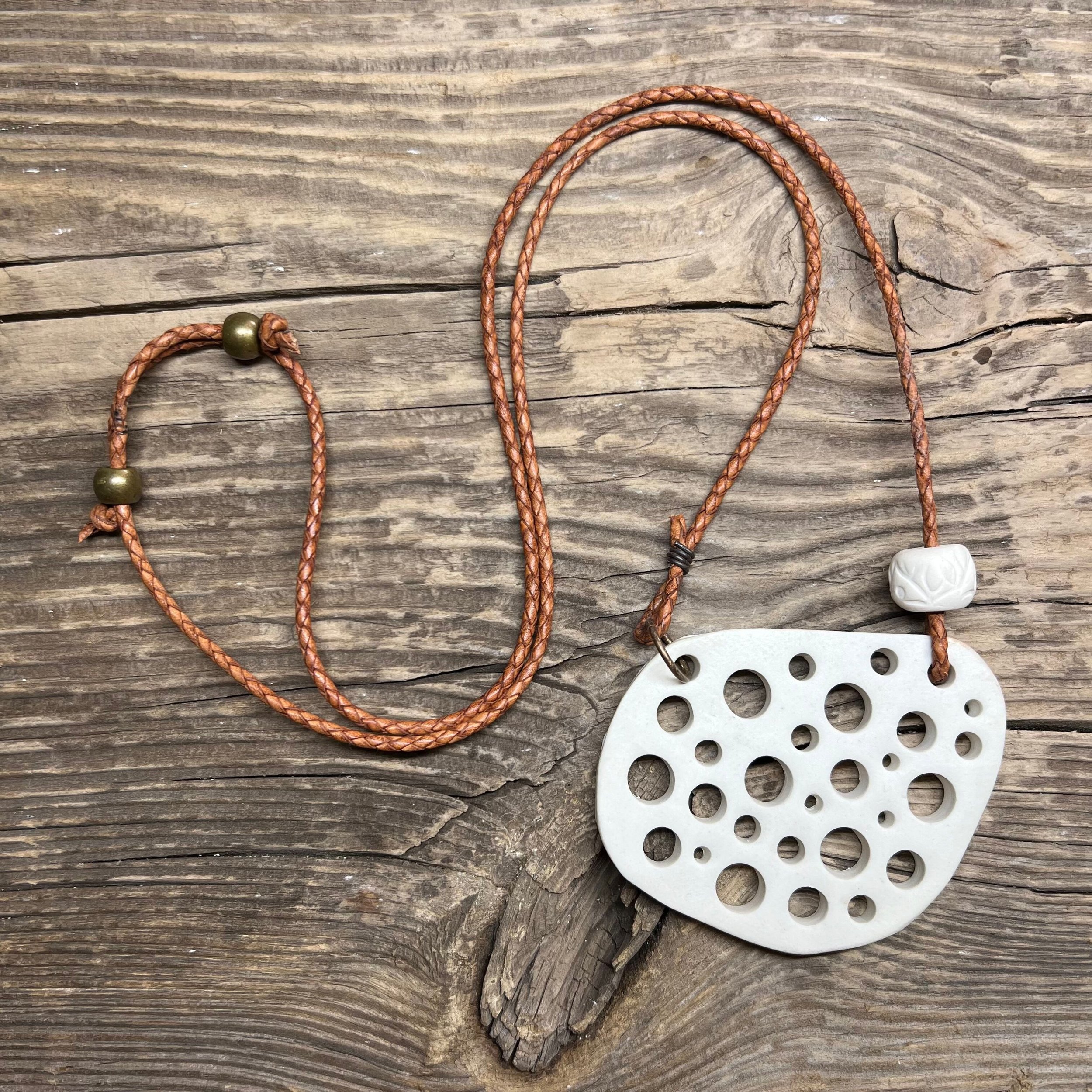 smooth white stoneware clay pendant and a handmade bead