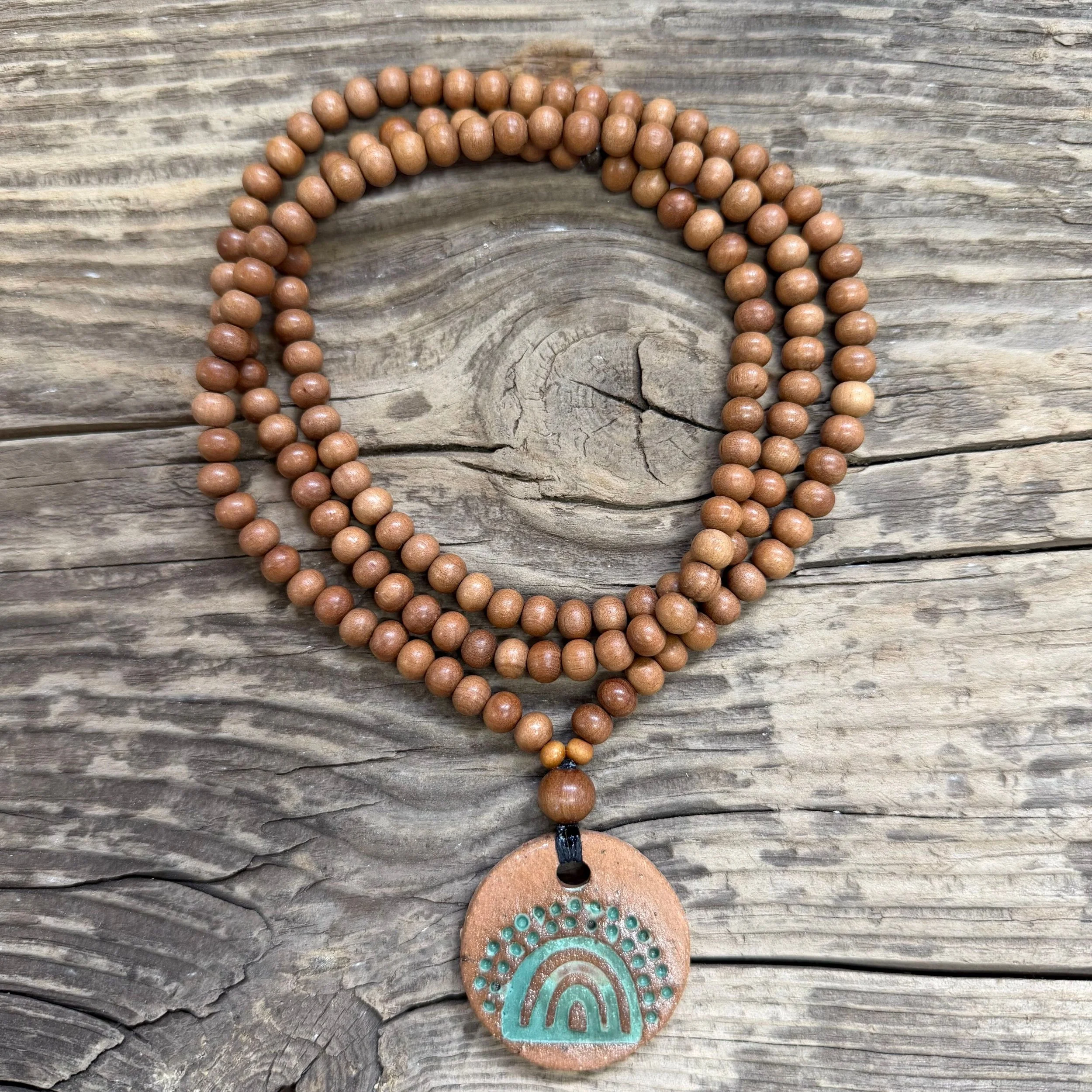 Round ceramic pendant with green glaze and sandalwood bead necklace