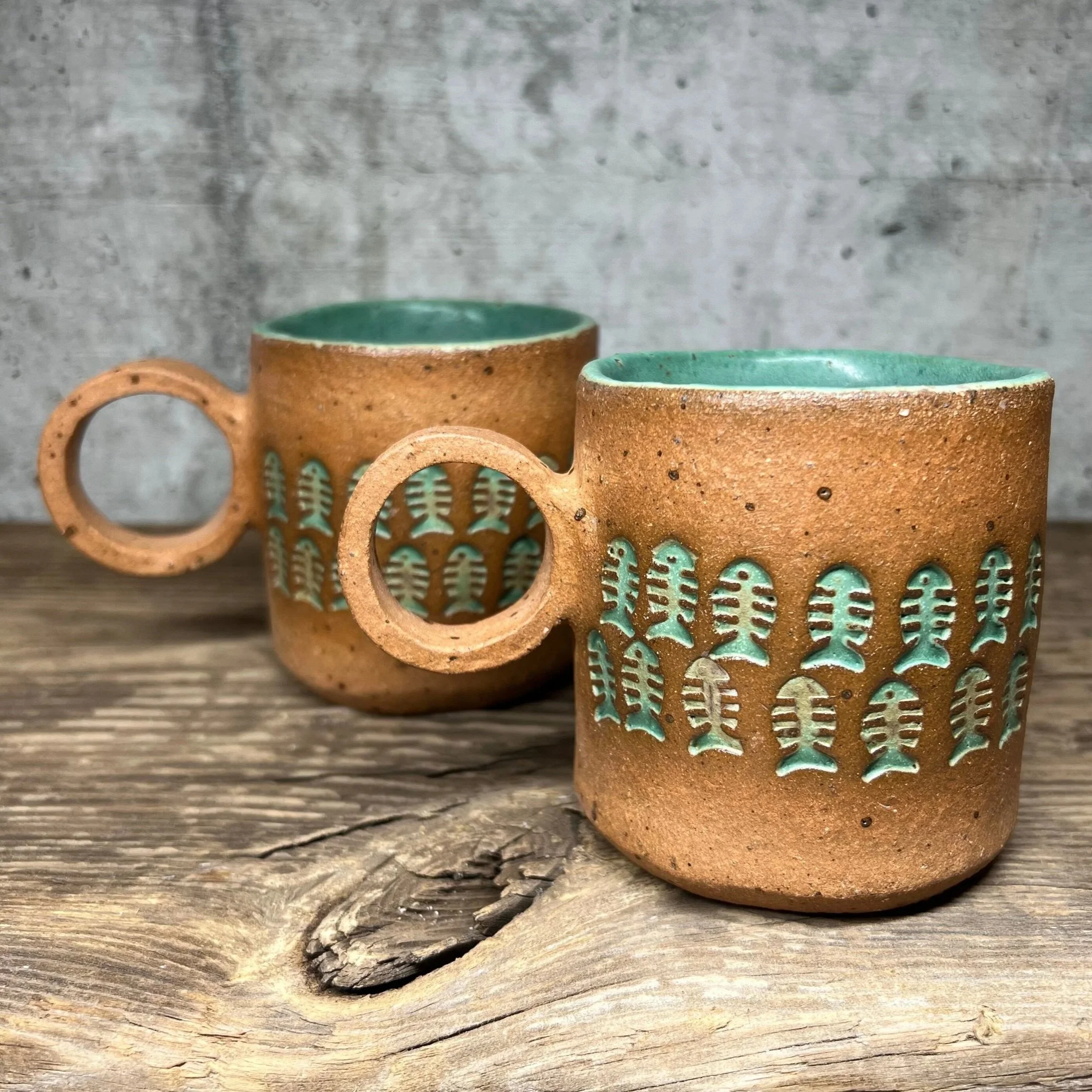 handcrafted cup, made from speckled stoneware clay.   Finished in a beautiful green glaze on the inside, inlaid on the outside and hand stamped with a fish.