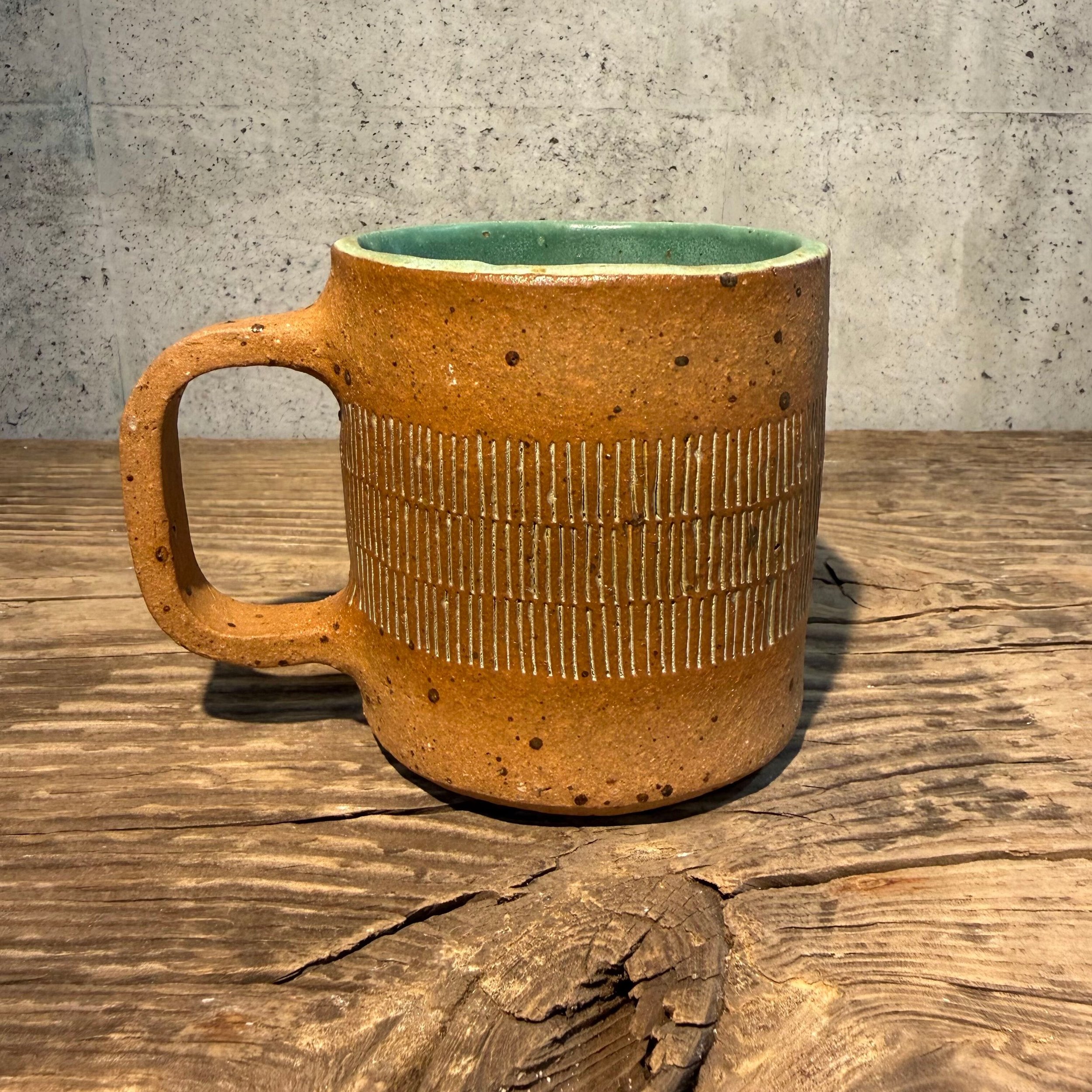 handcrafted cup, made from speckled stoneware clay.   Finished in a beautiful satin patina green glaze on the inside, inlaid on the outside