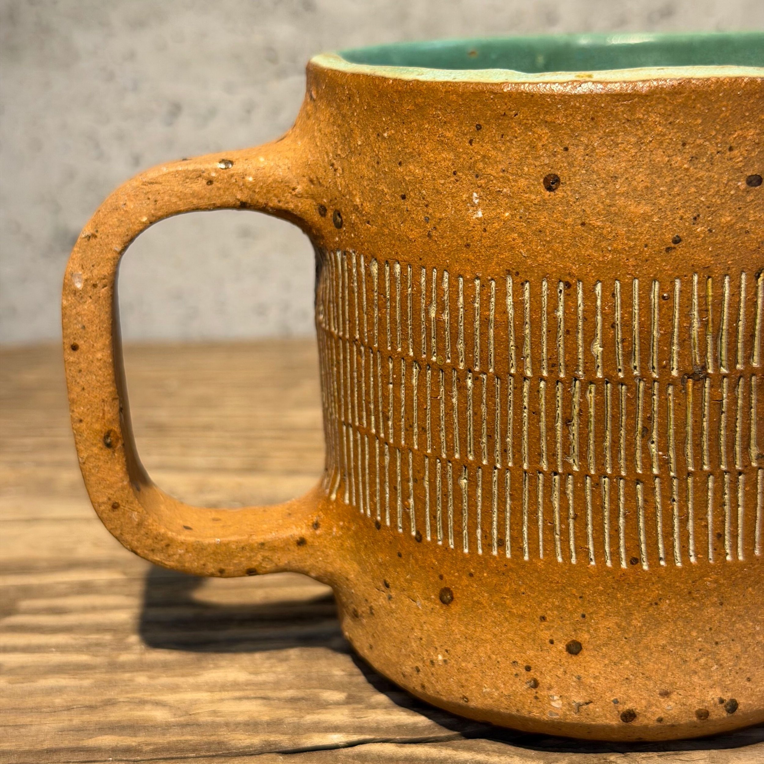 handcrafted cup, made from speckled stoneware clay.   Finished in a beautiful satin patina green glaze on the inside, inlaid on the outside