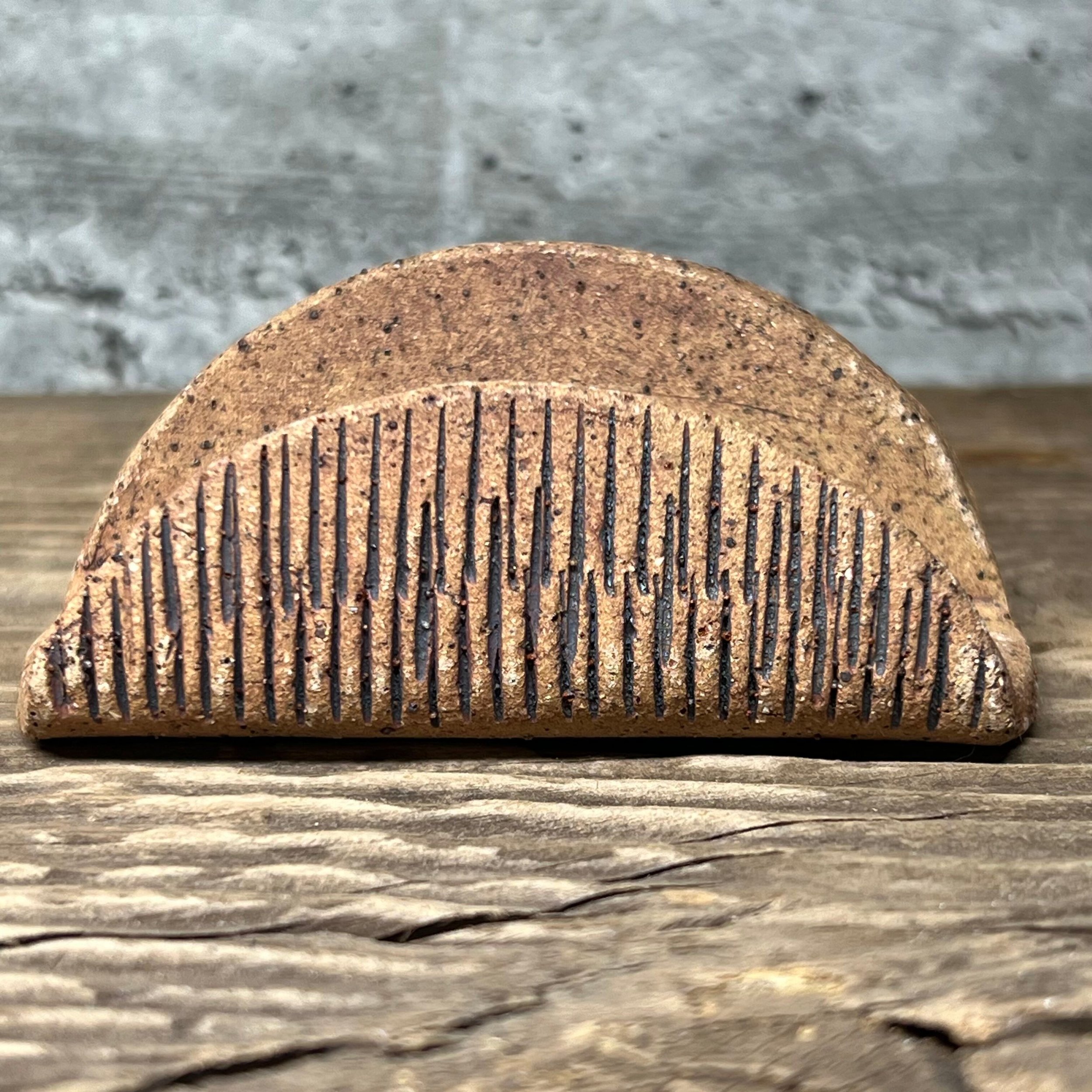 A textured handmade ceramic business card holder with an oxide wash.