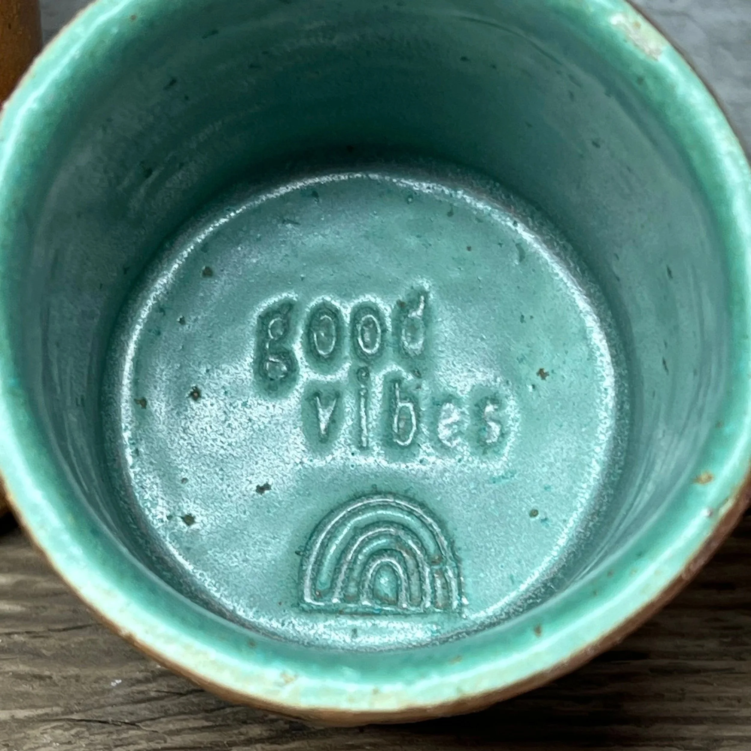 handcrafted cup, made from speckled stoneware clay.   Finished in a beautiful green glaze on the inside, inlaid on the outside and hand stamped with a fish.