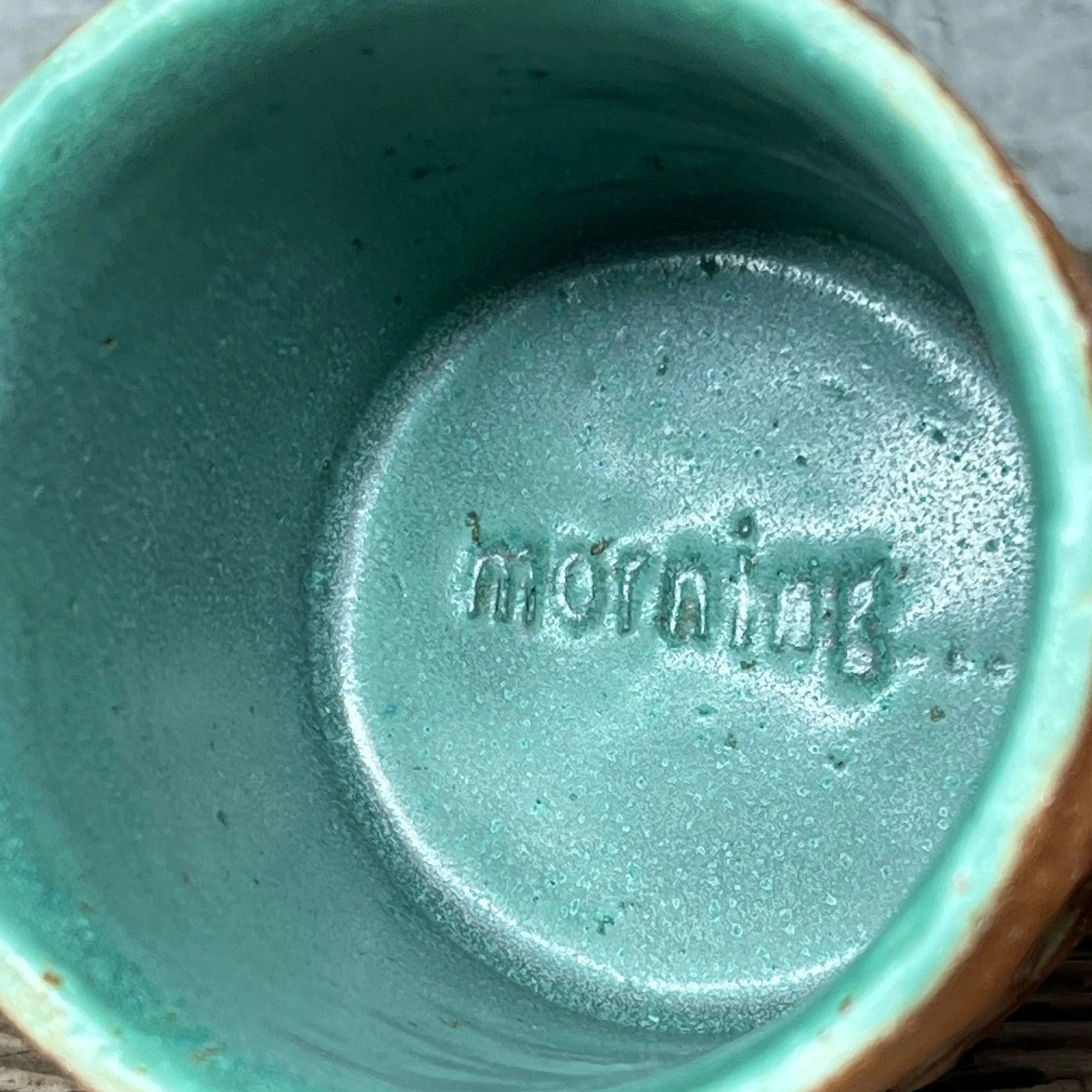 handcrafted cup, made from speckled stoneware clay.   Finished in a beautiful green glaze on the inside, inlaid on the outside and hand stamped with a fish.