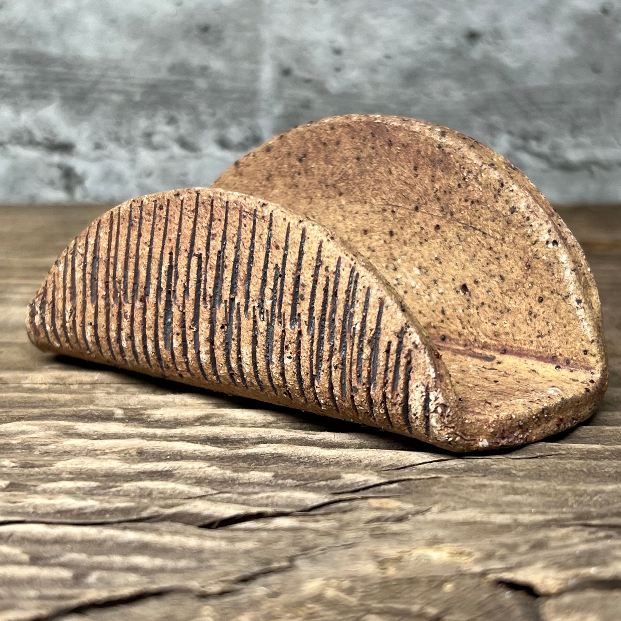 A textured handmade ceramic business card holder with an oxide wash.