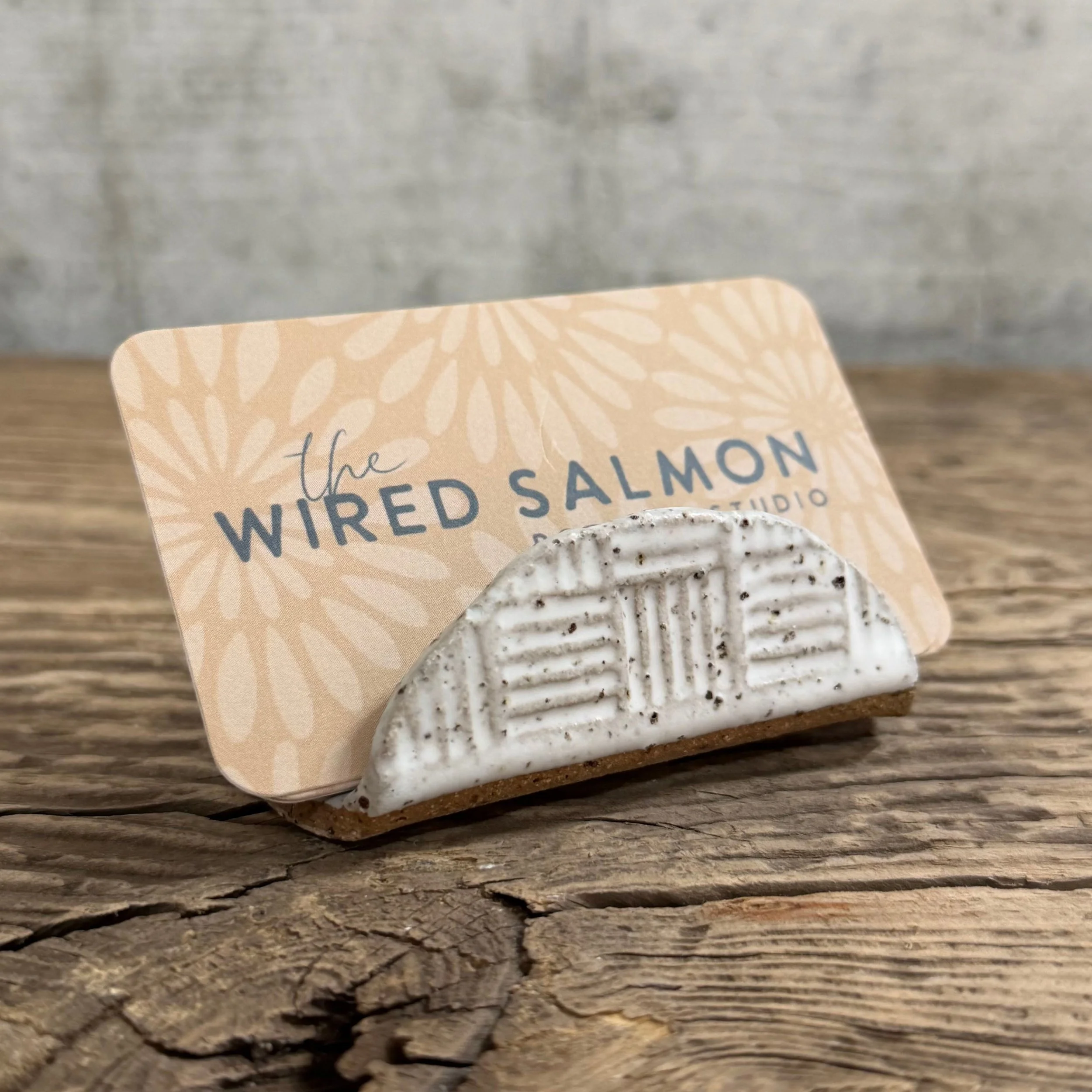 A textured handmade ceramic business card holder with a matte white finish