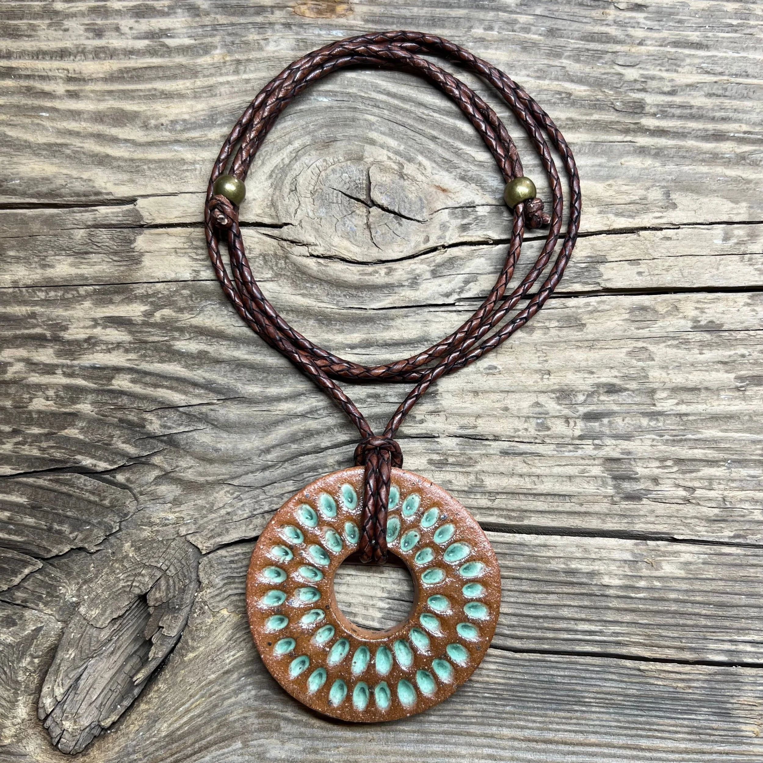 stoneware clay pendant finished in a rustic satin patina glaze inlay on leather cord