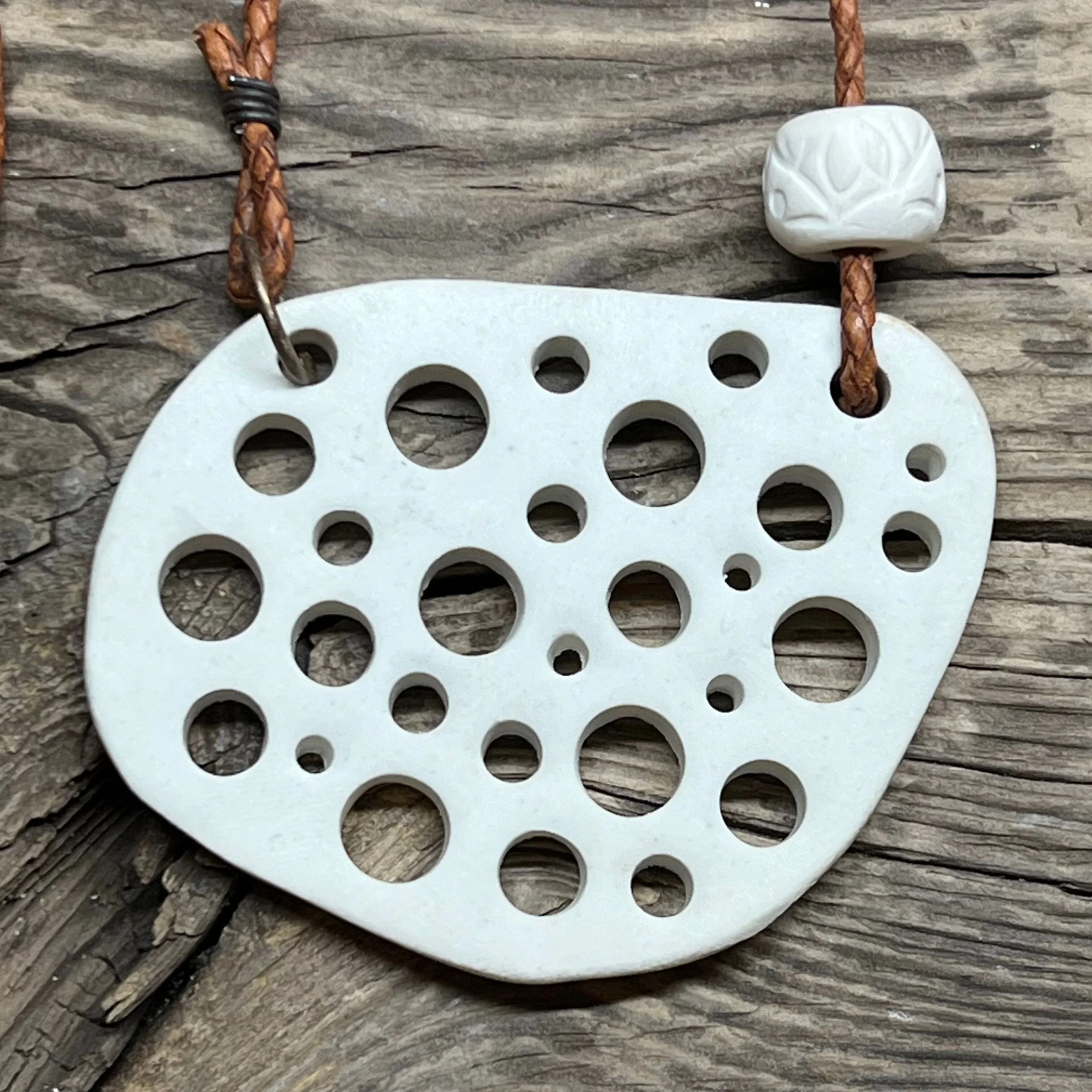 smooth white stoneware clay pendant and a handmade bead