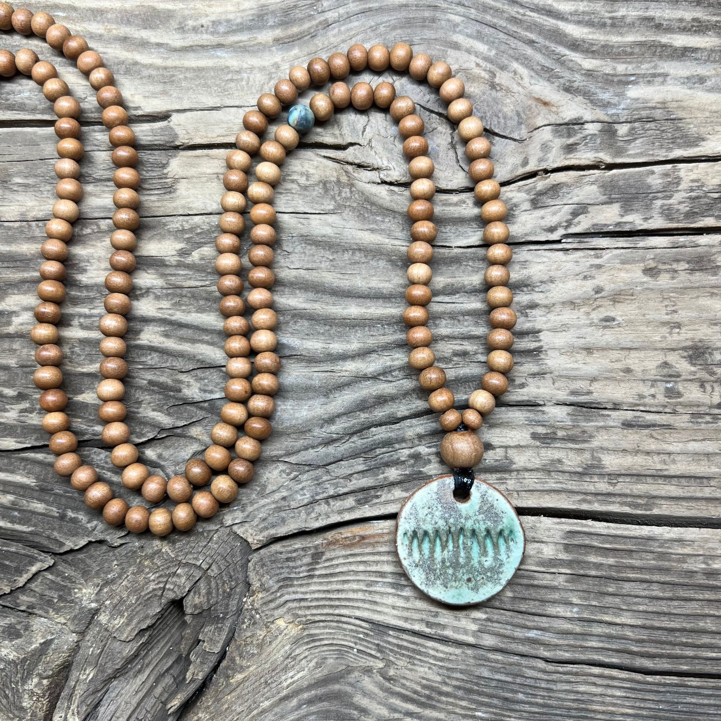 Round ceramic pendant with green glaze and sandalwood bead necklace